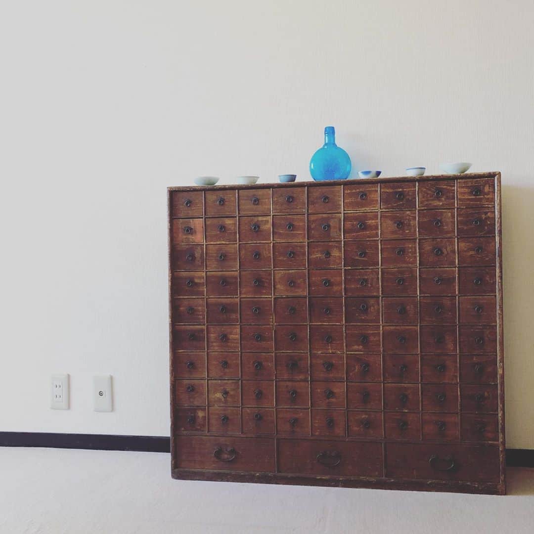 千秋さんのインスタグラム写真 - (千秋Instagram)「江戸時代の家具が我が家に。 200年前、幕末の薬箪笥。 84個の引き出しがあります。何を入れよう😍  骨董品屋さんの小川商店 @ogawashoten で見つけてずっと悩んでいたものを、お誕生日にいつものみんなが集まってプレゼントしてくれました✨  上に、この前ハワイのスリフトショップで即買いした青い瓶と、コツコツ集めている軍盃を並べました。  この時代に生きていた人間はもう誰もいないけど、この家具はしっかりわたしの家に佇んでいます。存在感。重み。なんだか勇気がもらえる家具です。  #骨董 #骨董品 #江戸時代 #幕末 #薬箪笥 #薬棚 #軍盃 #古い家具 #骨董家具 #アンティーク家具 #アンティーク #アンティークのある暮らし #千秋インテリア  インテリアはフォロワー数がキリのいい時に載せてる感じです」11月14日 20時43分 - chiaki77777