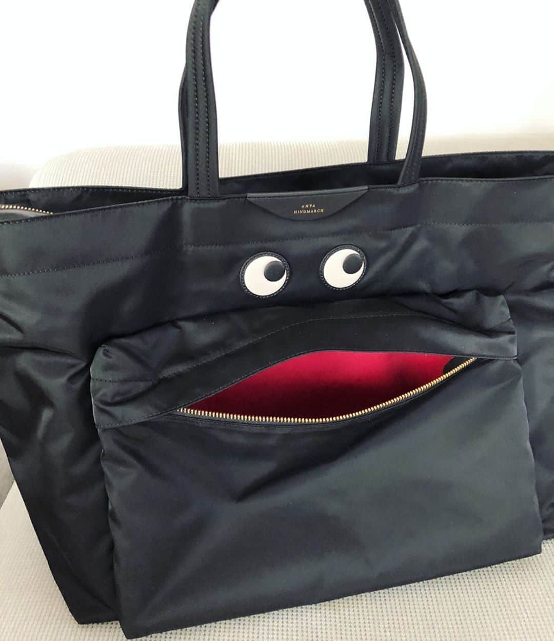 のインスタグラム：「✳︎ 夏に買ったアニヤのスマイリートート（3、4枚目）が旅バッグに便利すぎて、アイズトートも迎えてしまった❤️ . どちらも日本では取り扱いのないラージサイズ（最大辺55〜56cmくらい）なので、今回は楽天で購入。 来週の大阪出張でさっそく使おうかな。 . どちらもアウトポケットがユーモアがあって可愛い😍  こういうのがデザインなんだよなって思う✨ . . #アニヤハインドマーチ #anyahindmarch  @anyahindmarch @anyahindmarchpersonal （インナーポケットも可愛い 要するに全部可愛い）」