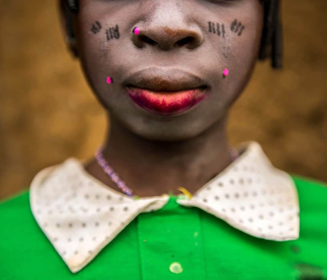 のインスタグラム：「Photo by @amivitale | This was taken during a Fulani baby-naming ceremony, and the girls put on lipstick for this special occasion. There were a lot of beautiful, healthy, fat babies there, despite this being a very dry and remote part of Benin. The women told me it was because of a solar-powered irrigated garden and how much it helped change their lives. They now had nutritious food to feed their children and the children were thriving. I was in Benin on assignment on behalf of @rippleeffectimages making a film about solar energy empowering women. Learn more by following @amivitale @rippleeffectimages @thephotosociety and @solarfund. #girls #benin #africa #solarpower」
