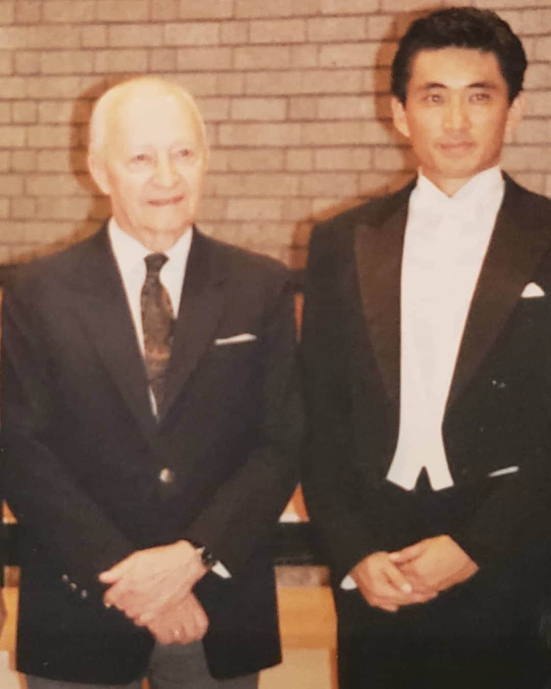 藤岡幸夫のインスタグラム：「仕事部屋を整理していたら懐かしい写真がでてきた。 1992年。ルトスワフスキの僕に対する態度とコメントは当時の僕には衝撃的でした…。(当時は英国やオーストラリアの発音のまま英語読みでルトスラウスキと書いてます。日本で習近平をシュウキンペイと発音するのと同じ)以前書いた文章です。 ↓  みなさん、お元気ですか？ オーストラリアの報告とマンチェスターの近況です。 僕はようやく一息ついているところです。 本当はクィーンズランドで、手紙を書こうと思っていた のですが、あまりに忙しく書けませんでした。 まずオーストラリアの報告をします。  タスマニアのコンサートはとてもうまくいって、 2000年の12月に再会することを約束して（丁度、新しい コンサートホールがこの時オープンするそうです！！）、 クィーンズランドへ。ところで、このコンサートのショ スタコーヴィェチはオーケストラ大健闘。とても、オー ストラリアの田舎オケとは思えない。とにかくレヴェル が高い！！ クィーンズランドに着いてからは、4日間オフがあったのに、 勉強が大変で遊べませんでした。クィーンズランドの県庁 所在地ブリズベンという町に滞在。気候はまだ夏で、日中 は約30度あって最高。時間さえあれば車をレンタしてサー ファーズパラダイスやゴールドコーストまでスッ飛んで 行ったのだけど（車で70分くらい）、今回はそれどころじゃ なくてほとんどHotelにこもりっきり。ただしホテルの屋外 プールで泳いで、イキヌキが出来たのが良かった。 クィーンズランド交響楽団とは初顔合わせ。最初はちょっと つかれ気味だったけど（オケは演奏旅行の直後だったので）、 すぐにスイッチが入って来て、とても楽しかった。 さて、今回のプログラムの中の1曲、ルトスラウスキのオケコン （「オーケストラのための協奏曲」を通称、オケコンと言いま す）は、想い出深い曲。 92年に僕は、ルトスラウスキの目の前で、この曲を指揮する機会 に恵まれました。この時、僕はこの曲のリハーサルが始まる3日ぐ らい前に、沢山の質問をかかえて、すでにマンチェスターに滞在 していたルトスラウスキに会いに行きました。ところが、  ルトスラウスキは僕がオケコンを振ると知りながら、会ってく れなかった。その時は「このクソオヤジ～、あぁそうですか、 僕は勝手に好きなように振ります。」と頭に来て、いよいよ 本番。コンサート終了後、ルトスラウスキはニコニコしながら 僕のところにやって来て（ちゃんと、コンサートには来てくれ たのです）、「本当に素晴らしかった。ありがとう。」 そして、「私がなぜあなたにこの前会わなかったか、わかり ますか？作曲者が一つの曲を書き終えた時、その曲は作曲者 から離れて演奏者にゆだねられるのです。私はルトスラウス キ、あなたは無名の若手指揮者。私が何か言えば、あなたは大き な影響を受けてしまうでしょう。それは良くありません。」僕は 結構感動して、「ありがとうございます。ところで、2楽章は メトロノームの早さより、遅くて申し訳ありません。」と言う と、彼は「いいえ、あのTempoで良かったですよ。あのメトロ ノームの早さは早過ぎます。」 僕は、「どなたが、あのTempoをお書きになったのですか？」 と聞くと、「私が、書きました。でも早過ぎます。いいです か、作曲者の書いたメトロノームなど、信じちゃいけません よ。」 僕は「・・・・・・。」この後、他の細かい事（オケコンに ついて）について色々話をして、最後に、「今日は久し振りに 自分の曲を楽しめました。」と一言言ってくれて別れた。 僕はとても嬉しかった。 そういう思い出の曲です。 さて、素晴らしいコンサートホール（サントリーホールに似ている） で、無事コンサート終了。団員さん達が何人も部屋に来てくれて、 ここのオケとも2000年の12月に再会を約束して、次の日に英国へ。 （次回は絶対ウィンドサーフィンをやるぞ！！）」