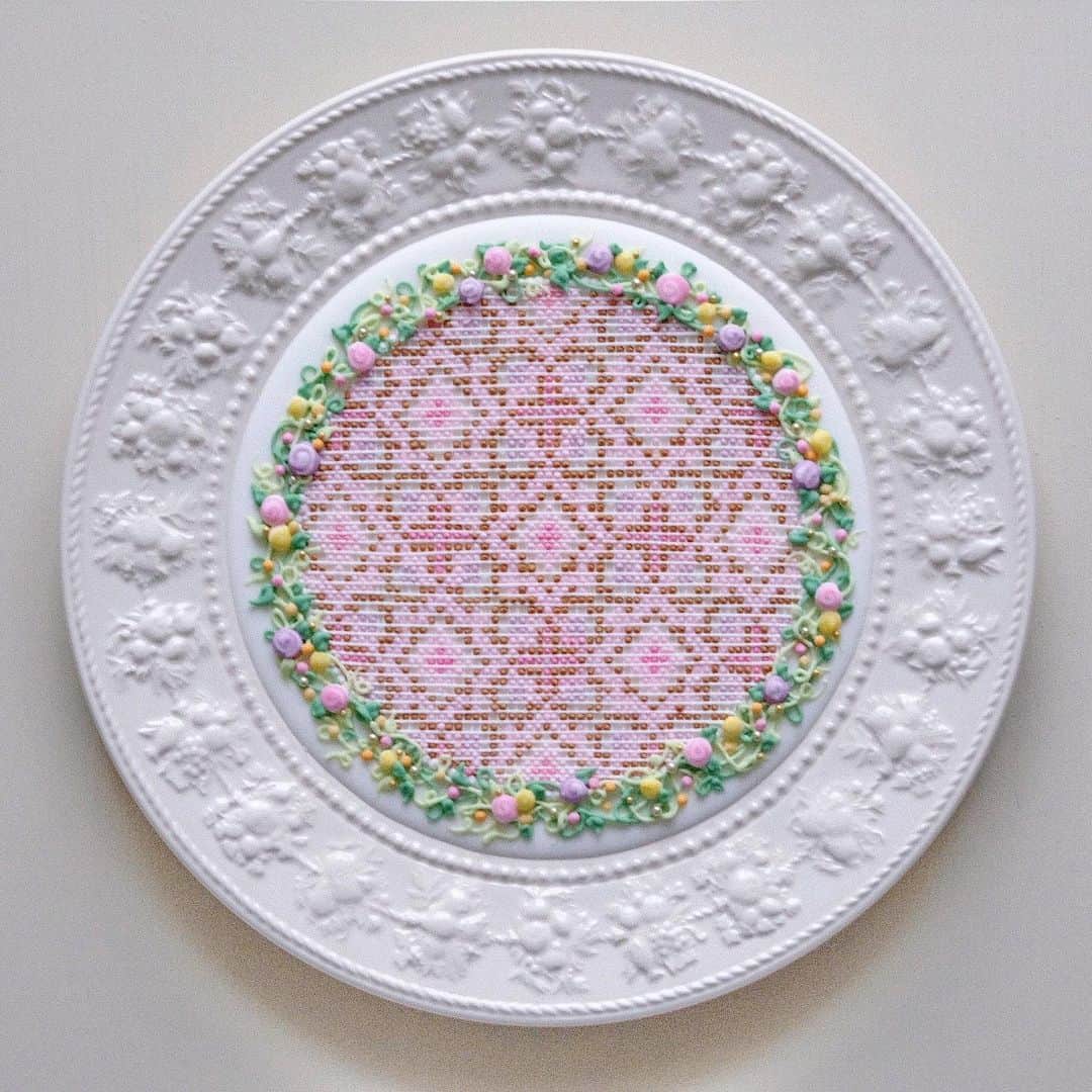 KUNIKAのインスタグラム：「Inspired by Ukrainian old handmade cross-stitch embroidery❃﻿ This is sugar art.﻿ ﻿ ウクライナの古都リヴィウで特にたくさん触れたクロスステッチの模様が可愛くて可愛くて。﻿ アイシングでクロスステッチアートしました🌷﻿ 実験的に適当に描き始めたから中心からズレてて悲しい🥺 次は真剣にやろう... ﻿ ﻿ #artofkunika #kunika #royalicing #embroideryart #embroiderydesign #lviv #ukraine #crossstitch #crossstitchersofinstagram #crossstitchpattern #crossstitch_inspiration #wedgwood #アイシングアート」