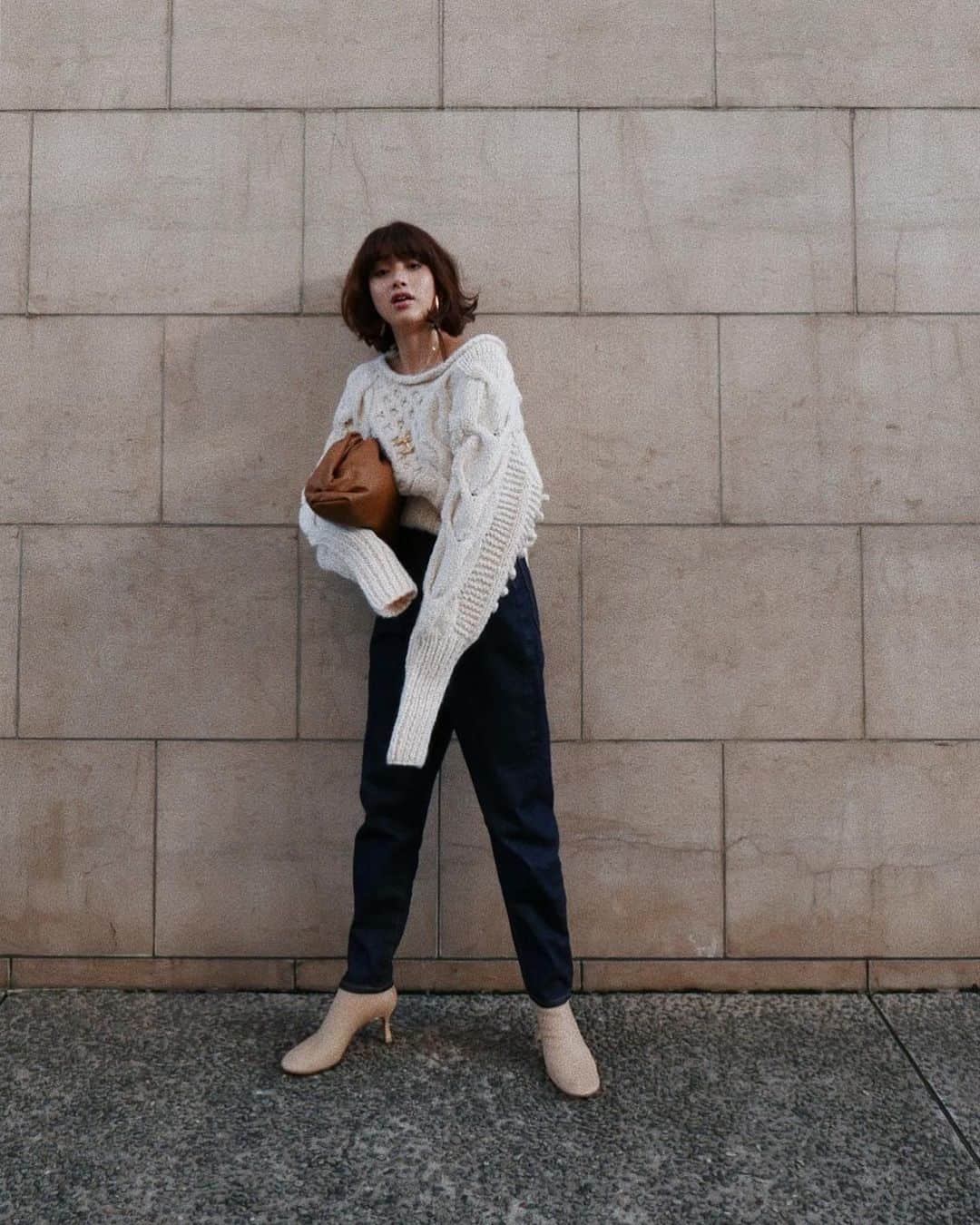 JUNNAのインスタグラム：「新作の発売を開始しました❤️ 20時からは　@etretokyo アカウントで ライブ配信をします😉  この #ローゲージケーブルニット は 袖の外側にはケーブル編み 内側にはポップコーン編みを施し 背中はバックオープンリボンデザイン。 デコルテ周りに動きをつけ、ボリューム、着丈  欲しい要素を全部詰め込んだ  拘りだらけ360度文句無しの一枚。  ボトムは2019年のデニムの中で1番気に入っている バナナ🍌シルエットのサルエルデニム。  合わせた靴は最近ずっと履いているnew in @pippichic_official のOblique toe Stretch Boots ！  tops/#ローゲージケーブルニット  10月31日19時発売 bottom/ #エトレサルエルデニム　10月31日19時発売 bag/ #BottegaVeneta boots/ #PIPPICHIC Oblique toe Stretch Boots 発売中  #etretokyo #junna👠 #2019ETREaw #156cm #bottegavenetabag#bottegavenetathepouch#ボッテガ #ボッテガヴェネタ#ニットトップス #ニットカーディガン #ニットコーデ #ボブ#ボブヘア #セリーヌ#ブーツ #ブーツコーデ #ボブ #ボブアレンジ #カジュアル#大人カジュアルコーデ #大人ボブ#ボブヘアー#エトレニット」