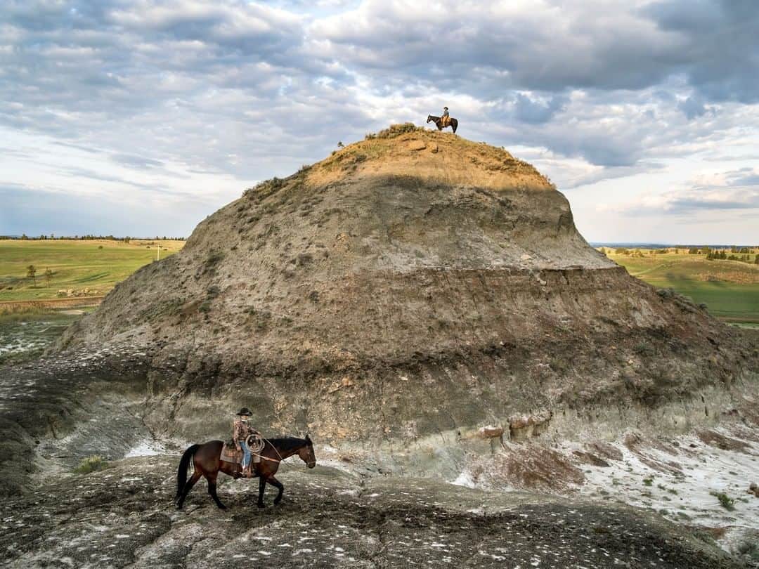 のインスタグラム：「Photo by Gabriele Galimberti @gabrielegalimbertiphoto and Juri De Luca | Fossils of long-extinct creatures aren’t just for museums. Today there’re in homes and businesses, as wealthy collectors indulge a controversial hobby.  Known in some circles as the “dinosaur cowboy,” rancher Clayton Phipps (at top) explores part of the Hell Creek formation near his home in Jordan, Montana, with his son Luke. The layers of fossil-rich rock date to the end of the Cretaceous period and contain a valuable record of the world just before the dinosaurs became extinct. Many scientifically important fossils have been found here, including the world’s first identified T. rex, in 1902. In the United States, fossils found on private property usually belong to the landowner, and collectors may strike deals with owners to dig on their land. Phipps says fossils generate the bulk of his income, so when he’s not tending to ranch duties, he works his land in a more lucrative way—scouring it for dinosaur bones. #dinosaur #fossil #extinct #dinosaurs」