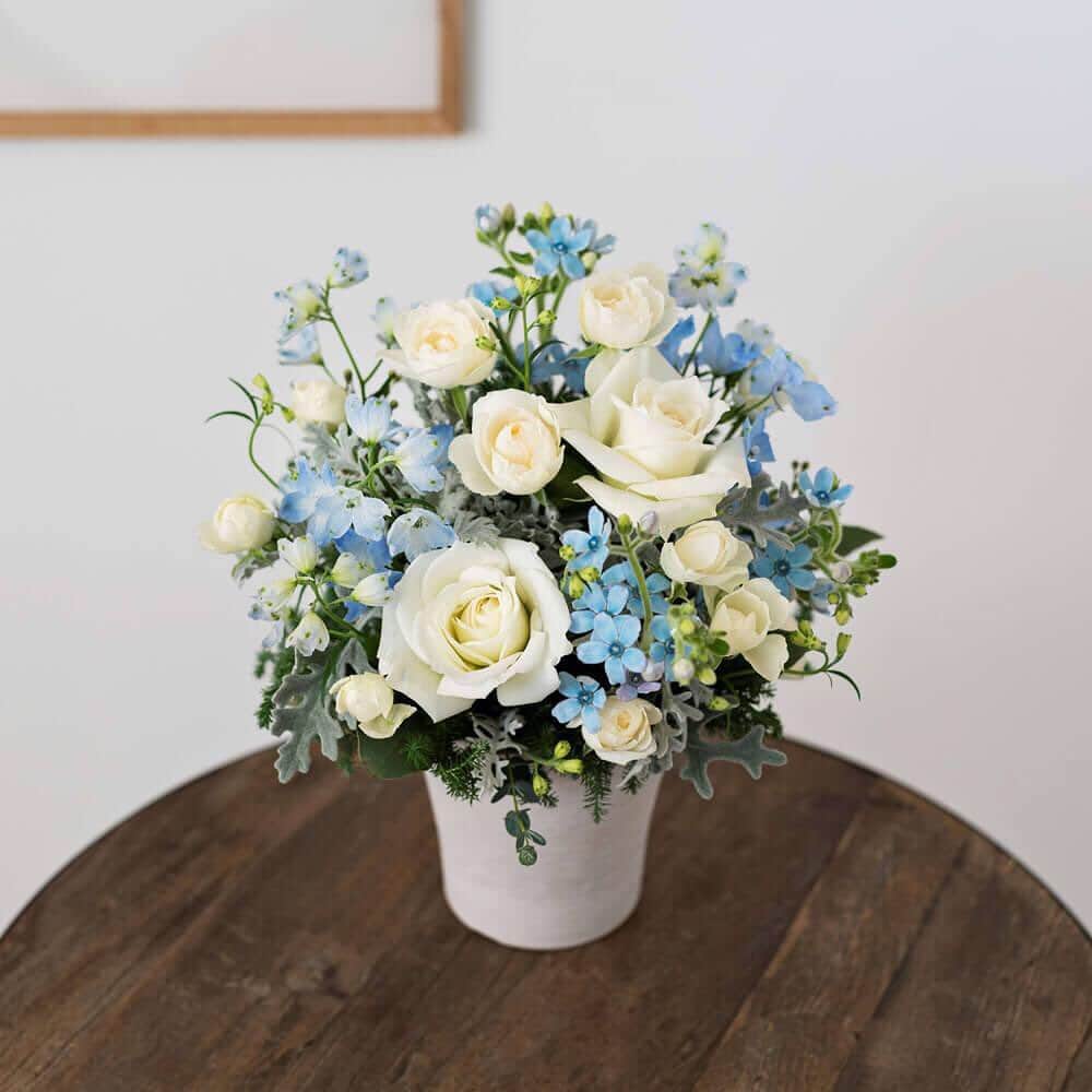 プシュケ[PSYCHE&]・花キューピットのインスタグラム：「. ピュアホワイトとサムシングブルーの花々で、幸せな2人を祝福するアレンジメントに仕上げました。 上品な白バラと、可憐なデルフィニウムは、ウェディングフラワーギフトに人気の花々。 結婚祝いや記念日を、忘れられない一日に演出します。 ｰｰｰｰｰｰｰｰｰｰｰｰｰｰｰｰｰｰｰｰｰｰｰｰｰｰｰｰｰｰｰｰｰｰｰｰｰｰｰｰｰｰｰｰｰｰｰｰｰｰｰ #プシュケ #花キューピット #花 #💐 #ザ花部 #サムシングブルー #ブルースター #デルフィニウム #カスミソウ #白バラ #冬 #冬の花 #クリスマス #winter #花束 #花に心を込めて #暮らしに花を #花のある暮らし #丁寧な暮らし #フラワーデザイン #インテリアフラワー #フラワーギフト #フラワーボックス #👰 #wedding #ウエディング  #結婚祝い #記念日 #プシュケ_Natural」