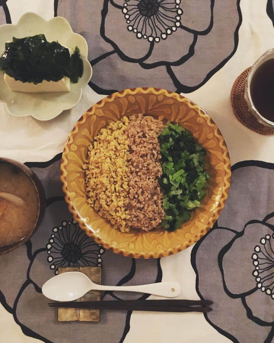 のインスタグラム：「鶏そぼろってなんでこんなに美味しいんでしょうね〜。 生姜とねぎのみじん切りをたっぷり入れるのは定番ですが、今日は蓮根を細かくしたのも一緒に炒りつけて、歯触りもよく。  緑は小松菜、黄色は炒り卵。  うむ。しっかり食べると力が湧くね。  #猫沢飯」