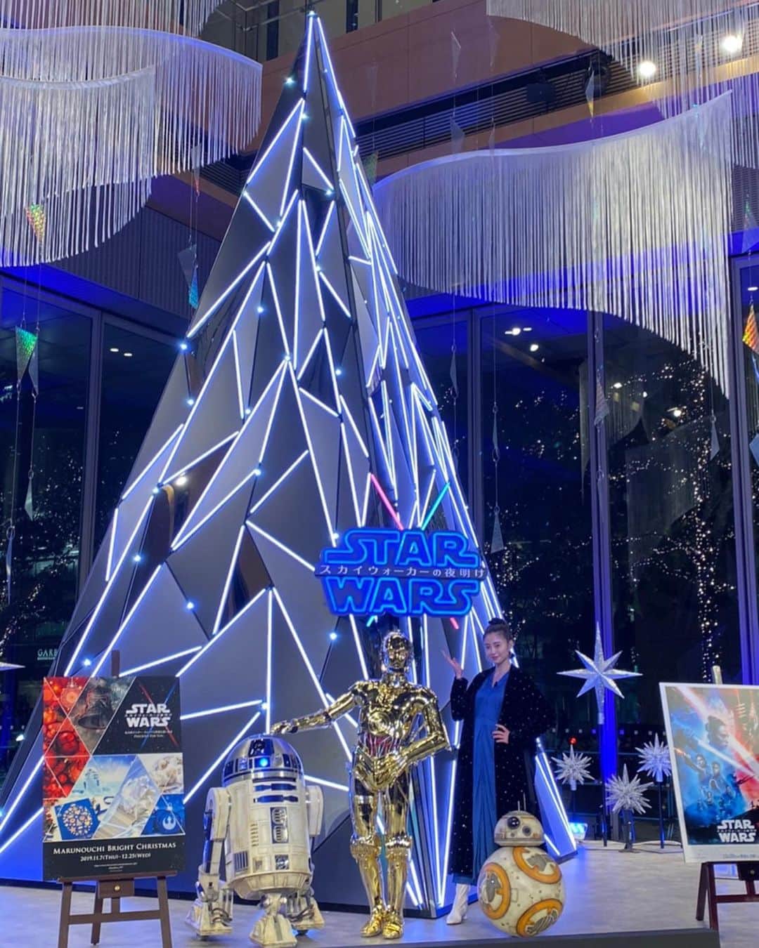 片瀬那奈のインスタグラム：「昨日『STAR WARS Marunouchi Bright Christmas 2019 -Precious for you-』クリスマス点灯式がありまして、ライトセーバーで点灯させていただきました🌟 C-3PO、R2-D2、BB-8まで登場して1ファンとして舞い上がってしまいましたが、当日誕生日だった私にとって1番のプレゼントになりました✨😆丸の内が今STARWARS色に染まっていて、オブジェやグッズ、グルメなどファンにはたまらない場所になっています🥰 私も何度も来ちゃいそうです💕 「STARWARSスカイウォーカーの夜明け」公開が待ち遠しいですね👀🎬 この時の衣装は#forte_forte ピアス#em です💁‍♀️👗ちなみに、私服は前にSTARWARS展で制作した革ジャンを着て来ました⭐️ #starwars #marunouchi #christmas #marunouchichristmas #c3po #r2d2 #bb8 #lightsaber #クリスマス点灯式 #丸の内」