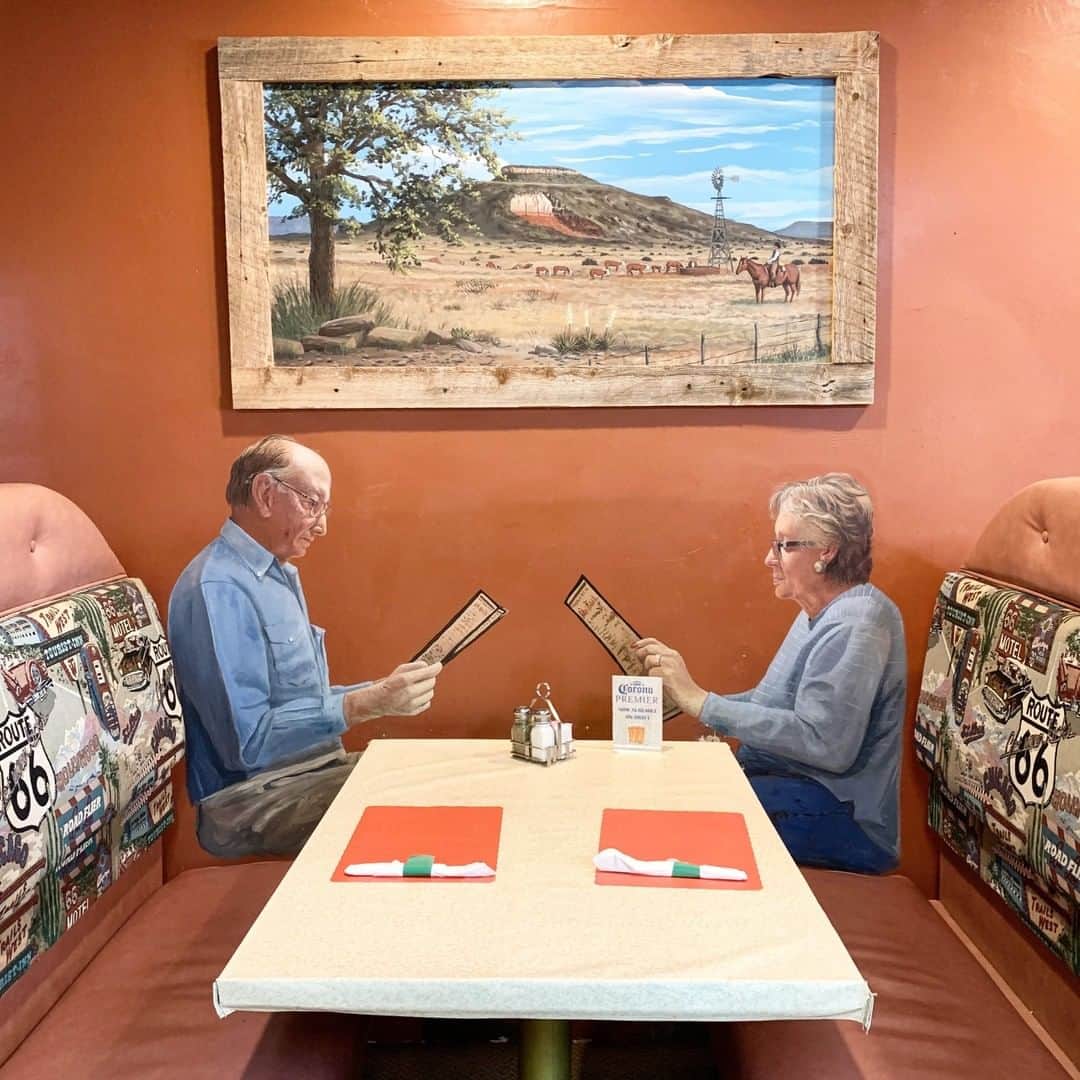 のインスタグラム：「Photo by David Guttenfelder @dguttenfelder | A dining couple is painted on a wall next to a breakfast booth at a Route 66 roadside restaurant in Tucumcari, New Mexico. We’ve been crossing the country, making a classic U.S.-style road trip. But we’re also driving electric cars, visiting renewable energy projects, and meeting people with innovative ideas about energy to see where we are, where we need to be, and how to get to a renewable energy future. On assignment for @natgeo on a renewable energy #roadtripto2070」
