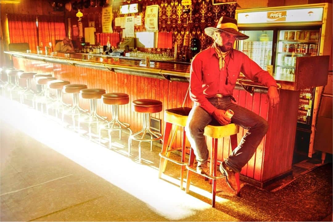 のインスタグラム：「Photo by William Albert Allard @williamalbertallard | Stan Kendall at the Miner's Club Bar, Mountain City, Nevada, 1979. A buckaroo crew and I went in one day to get supplies in the tiny hamlet of Mountain City, Nevada. Far from being a city, the community consisted then, as I recall, of a couple bars and a grocery store. It was late afternoon, and sunlight was blasting through the door, filling the room with red: Stan’s shirt, the curtains, the wainscoting on the bar, the barstool tops. It was as if the entire room was bleeding. Stan is kind of slumped there on the stool, a faraway look on his face. He had what I called that “leaving look.” And he did so the next day, packing up his bedroll and saddle, picking up his pay, and heading to another job on another ranch somewhere down the road. For more images of the American West and other assignments spanning a five-decade career #followme @williamalbertallard #nevada #red #bar #sunlight #cowboy」