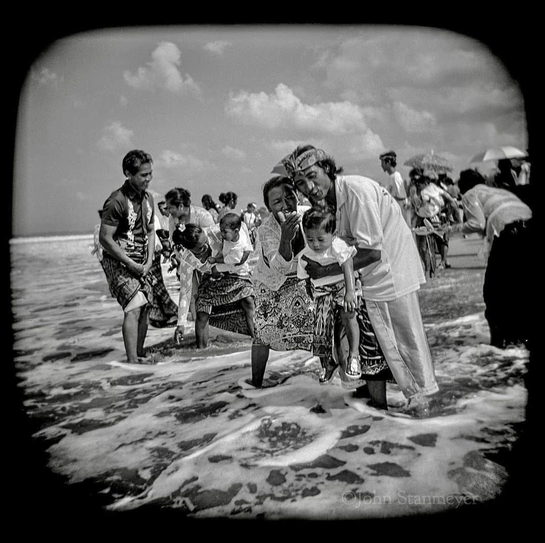 ジョン・スタンメイヤーさんのインスタグラム写真 - (ジョン・スタンメイヤーInstagram)「Sharing another beautiful time from the making of Island of the Spirits…in Balinese culture, children, as they should be, are considered divine, not yet recognized as part of worldly life. Once a baby is born, the child is carried by family or friends, never, ever, touching the ground until performing the sacred Pengelukatan (purification) ceremony. This can occurs months or even a year after birth, when being blessed by Sang Hyang Pertiwi, The Mother Earth, becoming full members of their family. The beauty, (and isn’t there so much in this life?!), is the first time a Balinese ever touches the earth, it is water… - Just five days remain to receive a free signed copy of my book, Island of the Spirits, with a purchase of a signed print for only $100. Please visit the link in my Instagram bio for ordering details or direct message if you have any questions. Wishing each of you a beautiful holiday, as beautiful as the time spend with children on Petitenget Beach in Bali, John - #islandofthespirits #signedprint #signedbook  #children #blessing #holga #bali #indonesia #petitenget #holidayprintsale #love」12月10日 1時57分 - johnstanmeyer