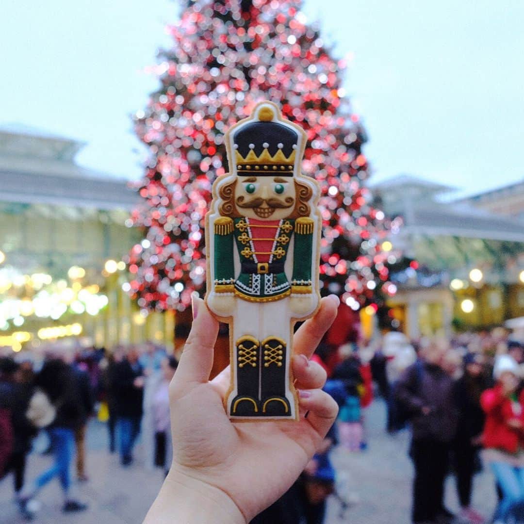KUNIKAのインスタグラム：「The nutcracker cookie 🥁🎄﻿ ﻿ ロンドンクリスマスツアー2日目。﻿ The savoyでアフタヌーンティーをしたあと、歩いてすぐ近くのコベントガーデンへ。﻿ 観光の際、このルートはおススメです❤︎﻿ 大きな大きなクリスマスツリーがそびえ立ってます🎄﻿ 弦楽器の生演奏や大道芸人さんたちのパフォーマンスなど、常に人で賑わっている場所。﻿ ここで少しお買い物タイムでした。﻿ ﻿ 私は @biscuiteersltd のクッキーでできたコベントガーデンの展示を見たり、お客様とお店をいろいろ見たり。﻿ コアなおもちゃ博物館@pollockstoymuseum のショップも二階にひっそりとあります。﻿ ﻿ その後は @theofficialselfridges へ移動して再びお買い物タイム🛍﻿ 偶然にもブラックフライデーに重なり、ものすごい人で溢れていました。﻿ 日本ではセールにならないブランドもセールになったりします。 ここはお土産にぴったりなチョコレートブランドがほとんど揃ってるので、必ずツアーではご案内しています。﻿ ﻿ そしていよいよお待ちかねのウィンターワンダーランドへ...🎡﻿ ﻿ ﻿ ﻿ #kunikalondonxmastour #artofkunika #sugarcookies #decoratedcookies #cookieart #decoratedsugarcookies #royalicing #royalicingcookies #cookiedecorating #customcookies #cookiesofinstagram #cookiedesign #cookieartist #instacookie #london #londonchristmas #nutcracker #coventgarden #アイシングクッキー #ロンドン #ロンドンツアー #エイチアイエス ﻿ ﻿ ﻿」