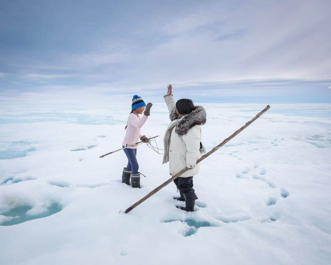のインスタグラム：「Photo by Acacia Johnson @acacia.johnson | On the spring sea ice, 10-year-old Horizon Willie gets a high five from her aunt, Leesie Naqitarvik, during a seal hunting trip on Canada's Baffin Island. The Inuit people lived a seminomadic hunting lifestyle here for nearly 5,000 years before settling in towns in the 1950s. As traditional life fades into memory, many families strive to preserve their cultural legacy by taking their children on long camping trips every spring, passing on traditional knowledge and skills. Leesie had traveled from her home in Ottawa to join her extended family for this important annual event.  Follow me @acacia.johnson for more stories from the Arctic and beyond. #arctic #inuit #baffinisland」