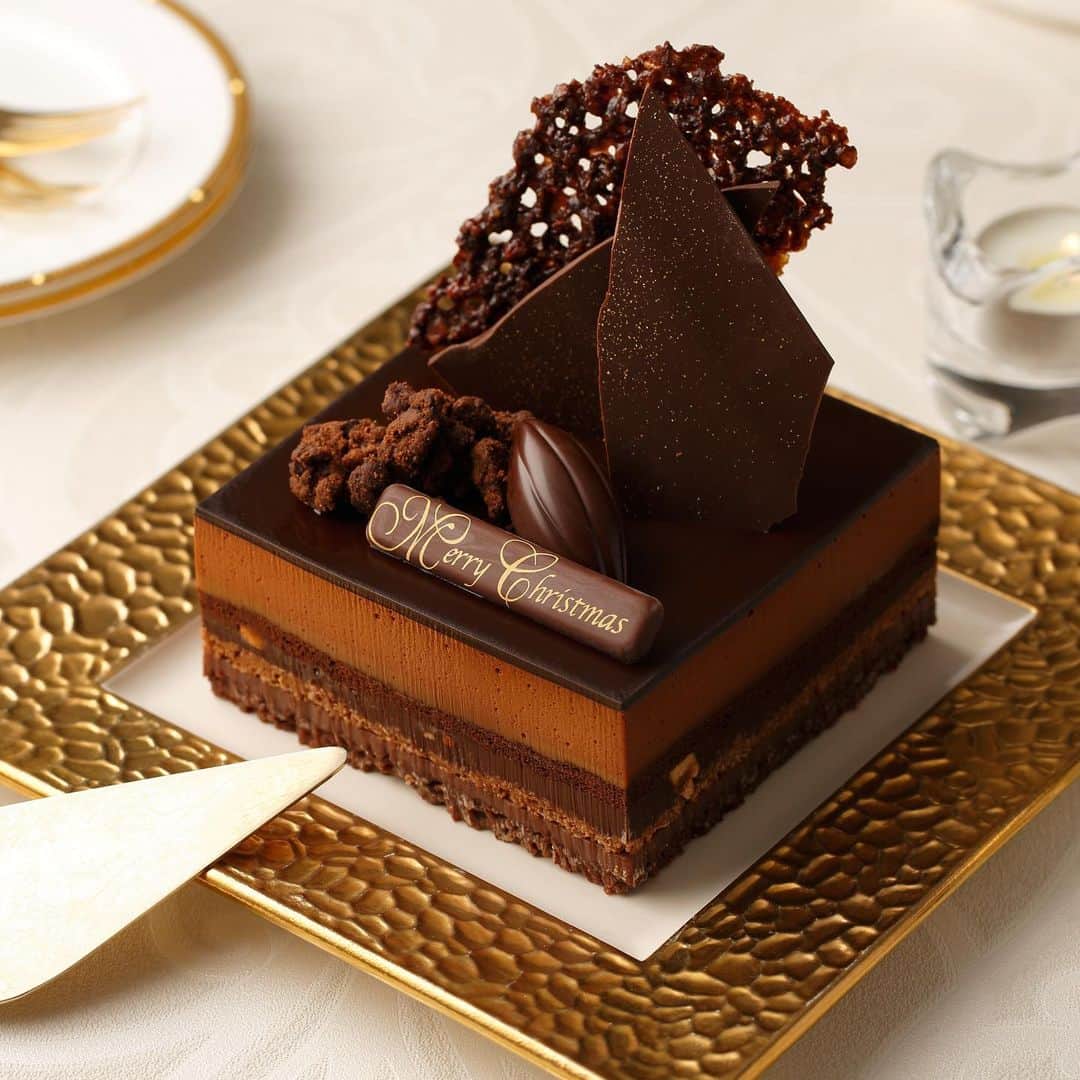 のインスタグラム：「◆ムッシュ・ショコラ・アメール﻿ ﻿ オンライン限定のクリスマスケーキ。﻿ カカオ型チョコレートやサクサクとした網目状のチュイールダンテル、クッキークラムや飾り用チョコレート等を別添えでお届けいたします。﻿ ﻿ ﻿ クリスマスはやっぱり準備も楽しい。﻿ お気に入りのリースや小さなツリーを手にいれて、自分好みのオーナメントを作ったり、テーブルクロスで気分を変えてみたり。﻿ ﻿ 今年はシックで大人なクリスマスもいいかも◎﻿ お家で素敵なクリスマスが過ごせますように＊﻿ ﻿ http://chocolatedesign.co.jp/shopbrand/ct46﻿ ﻿ ﻿ ※店舗限定「ボンボヤージュ」と同じタイプのケーキです。﻿ ※公式オンラインショップは﻿ 🔍「チョコレートデザイン」で検索﻿ ﻿ ﻿ #vanillabeans #chocolate #cacao #christmas #xmas #christmascake #cakes #バニラビーンズ #チョコレート #チョコレートケーキ #カカオ #クリスマス #クリスマスケーキ #クリスマスケーキ2019 #クリスマスケーキ予約 #お取り寄せスイーツ #お取り寄せケーキ」