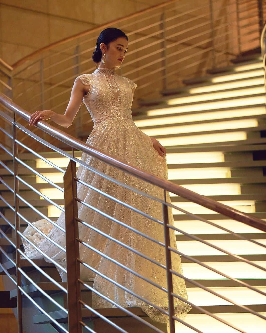 Magnolia Whiteさんのインスタグラム写真 - (Magnolia WhiteInstagram)「@grandhyatttokyo のロビーからチャペルへ続く『光の階段』でのショットです。ドレスはシルバーの煌めきが美しい、Galia LahavのGALA-803を着用しています。華やかでエレガントなハイネックのドレスは、ラグジュアリーなホテルウェディングにぴったりの1着です。﻿ ※ドレスは製作期間として約4~5ヶ月いただいております。﻿ ﻿ ご試着をご希望のお客様はMAGNOLIA WHITE omotesandoまでお問い合わせくださいませ。皆様のお越しをお待ちしております。﻿ ﻿ MAGNOLIA WHITE omotesando﻿ Tel. 03-6434-1313（火曜定休）﻿ Mail. info@magnolia-white.com﻿ ﻿ The GALA-803 by @galialahav is a sheer ball-gown with a high neck a cap sleeves, peek-a-boo cleavage and a sheer belt with a voluminous skirt, in a combination of Nude and Silver.﻿ ﻿ @ru0711  @youa.dressstylist  @knoxandtaylor﻿ ﻿ #magnoliawhite #mwhawaii #galialahav #G302 #weddingdress #weddinggown #bridalgown #hawaiiwedding #grandhyatttokyo #マグノリアホワイト #ガリアラハヴ #ウエディングドレス #レースドレス #インポートドレス #オーダードレス #ドレス試着 #ドレス選び #プレ花嫁 #海外ウエディング #海外挙式 #ハワイ挙式 #ハワイウエディング #ハワイ婚 #リゾートウエディング #リゾ婚 #ホテルウエディング #ホテル婚 #ホテル挙式 #グランドハイアット東京 #グランドハイアット」12月11日 18時58分 - magnoliawhite_official