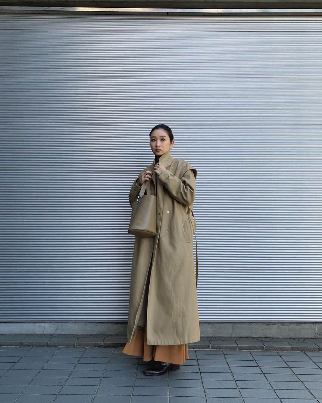 のインスタグラム：「.﻿ ライナー付き(取り外し可)スプリングコートが﻿ とてもかっこよく仕上がりました☻﻿ ﻿ この前の海外出張に持って行き、﻿ 試しに着てみてたけど﻿ コンパクトな二重織コットン素材で﻿ 生地は柔らかくとても着心地がいいです。﻿ ﻿ 暖かくなったらライナーを取り外し﻿ さらっと一枚でも◎﻿ ブログに詳細書きましたので是非🙏🏼﻿ ﻿ BLKは @yoshino_sasaki 着用♡﻿ ﻿ Spring liner trench CT 42.000  12/18-﻿ Shawls volume knit gown 21.000  12/18-﻿ Crepe flare maxi SK 16.000  12/18-﻿ Leather bucket mini bag 18.000  12/21-﻿ ﻿ #RIMARK#RIMARK_staffsnap  #RIMARK_SpringlinertrenchCT #RIMARK_Shawlsvolumeknitgown」