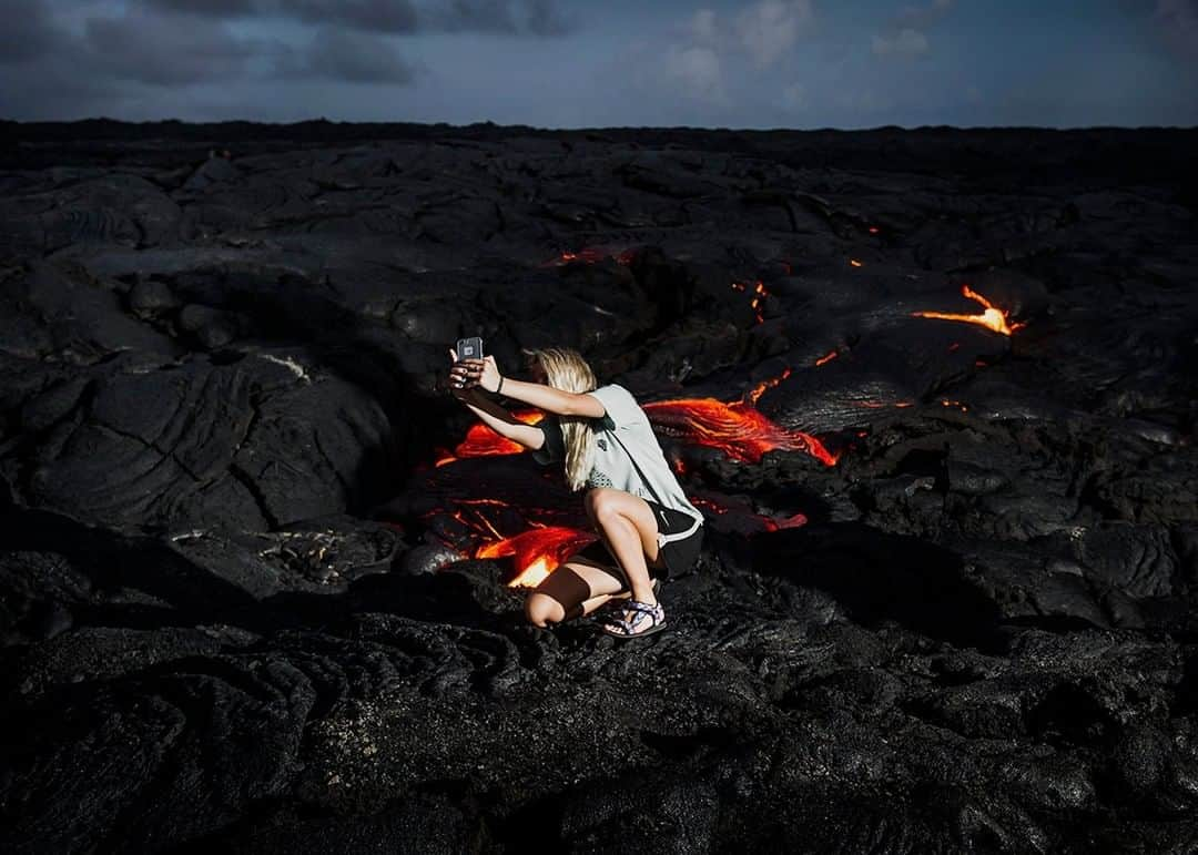 ナショナルジオグラフィックさんのインスタグラム写真 - (ナショナルジオグラフィックInstagram)「Photo by @dina_litovsky | A young woman takes a selfie in Hawaii’s Volcanoes National Park, just a couple feet away from free-flowing lava from Kilauea, the youngest and most active volcano on the Big Island. Volcano tourism has become a big business in the last few years, with volcanophiles traveling around the world to get as close to active volcanoes as possible. Geologists have long warned that such tours are dangerous, since most eruptions happen suddenly and without warning. For more images, follow me @dina_litovsky」12月12日 13時01分 - natgeo