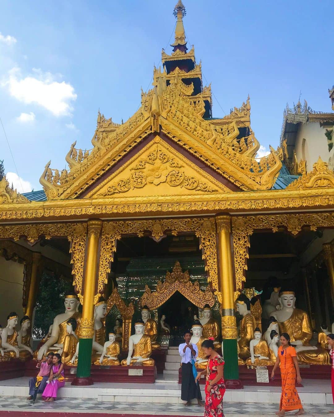 D[di:]さんのインスタグラム写真 - (D[di:]Instagram)「バンコクから、ヤンゴンへ﻿ ﻿ カックー遺跡を見るために、お次はミャンマー🇲🇲入り。﻿ トランジットのヤンゴンで7時間も待ち時間があったので、空港から出てシュエダゴン・パゴダというミャンマーで2番めにでかい(なんと高さ105メートル‼️の仏塔)を﻿ 観に(この時私は、やたらとでかい荷物を持ってきたことをむちゃくちゃ後悔した)﻿ ﻿ ミャンマーの人にとって、とにかくむちゃくちゃ神聖な場所である、シュエダゴンパゴダ。巨大なパゴダを中心に数々の仏教建築(とにかく金色)がたくさん‼️そして広大‼️たくさんのミャンマー人でごった返していました。﻿ ﻿ ところで、ミャンマーの人ってやたらと若者人口が多くて、しかも美男美女が、マジで多い‼️﻿ 笑顔も可愛いし、デートにパゴダ❤️みたいなカップルめちゃくちゃ多いし…健全すぎてユートピアかと思いましたわ﻿ ﻿ 写真じゃ、マジでか！っぶりが伝わらないんじゃないか…こんな大きな建物は、豊島美術館での衝撃に近い。﻿ ﻿ 3.自分の生まれ曜日のお釈迦様にお水をかける祈り。わたしもやってみました。﻿ ﻿ 6.柱などの細工がいちいちすごい﻿ ﻿ 7.ミャンマーは雲までも荘厳…ため息しかでなかった﻿ ﻿ 9.さらに、シュエダゴンのあとは、どんな隙間にもマッサージな、うちら。てなわけで、シュエダゴン・パゴダからそう遠くない場所にマッサージ店があったので、Grabでタクシーを呼んで行ってみました。﻿ 店内少しカビくさいけど、音楽のチョイス、足洗い桶に花びら散らしていたり、店内絶妙にうすぐらく、ウデもなかなか。太ももまで、フットマッサージしてくれてなかなか良かったです﻿ ﻿ 10.ちなみに、バンコクをでる夜中、なんと我々の泊まっていたホテルの前のとおりで、マラソン大会やってました。お囃子がだいぶ派手で凄かった@am3:00﻿ ﻿ #ミャンマー　#シュエダゴンパゴダ﻿ #女子旅　#ヤンゴン　#ShwedagonPagoda﻿ #yangon #Myanmar」11月19日 0時38分 - deeth