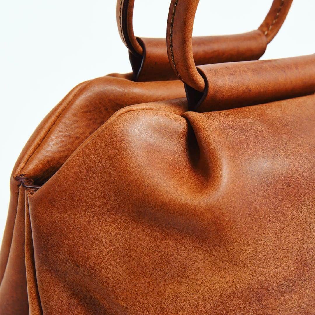 HERZ ヘルツさんのインスタグラム写真 - (HERZ ヘルツInstagram)「#旅モノ 2019﻿ オンラインショップ販売アイテムをピックアップ！﻿ ﻿ 【タックハンドバッグ(TB-1928)】﻿ @organ_leather の作り手による、旅先にも普段使いにもおすすめのハンドバッグ。﻿ 実はこの鞄。旅モノ販売前にスタッフ内でお披露目会をした時に一番人気のあったものです。﻿ ﻿ 商品名の通り、作り手が拘ったのは、タックの作り。﻿ 本体前後面合わせて8カ所にタックを作り、ぽってりとしたフォルムにしています。﻿ ﻿ 鞄本体の雰囲気と一体感を出すために取っ手も丸い形に。﻿ 全体を通してステッチが目立ちにくい作りにしており、スッキリとした見た目にしています。﻿ マチ上部のホックを外せば、収納部がガバっと開き、容量もアップします。﻿ 内側前後面にあるポケットは女性に嬉しいファスナー式。﻿ タックを入れた分、ポケット自体の容量も多く、沢山収納できるところも使い勝手に貢献しています。﻿ ﻿ 革はOrganで使用している #イタリアンレザー の #ミッスーリ を使用。﻿ あまり可愛くなり過ぎないように、表情が強めのミッスーリで作りました。﻿ ﻿ #ヘルツ #organ #organbag #ハンドバッグ #レディースバッグ #旅行鞄 #作り手 #革職人 #旅行鞄 #革 #イタリア革 #革鞄 #革製品 #革小物 #herz #herzbag #leather #bag #leatherbag #leathergoods #handbag #ladiesbag #madeinjapan #factory」11月20日 11時23分 - herz_bag