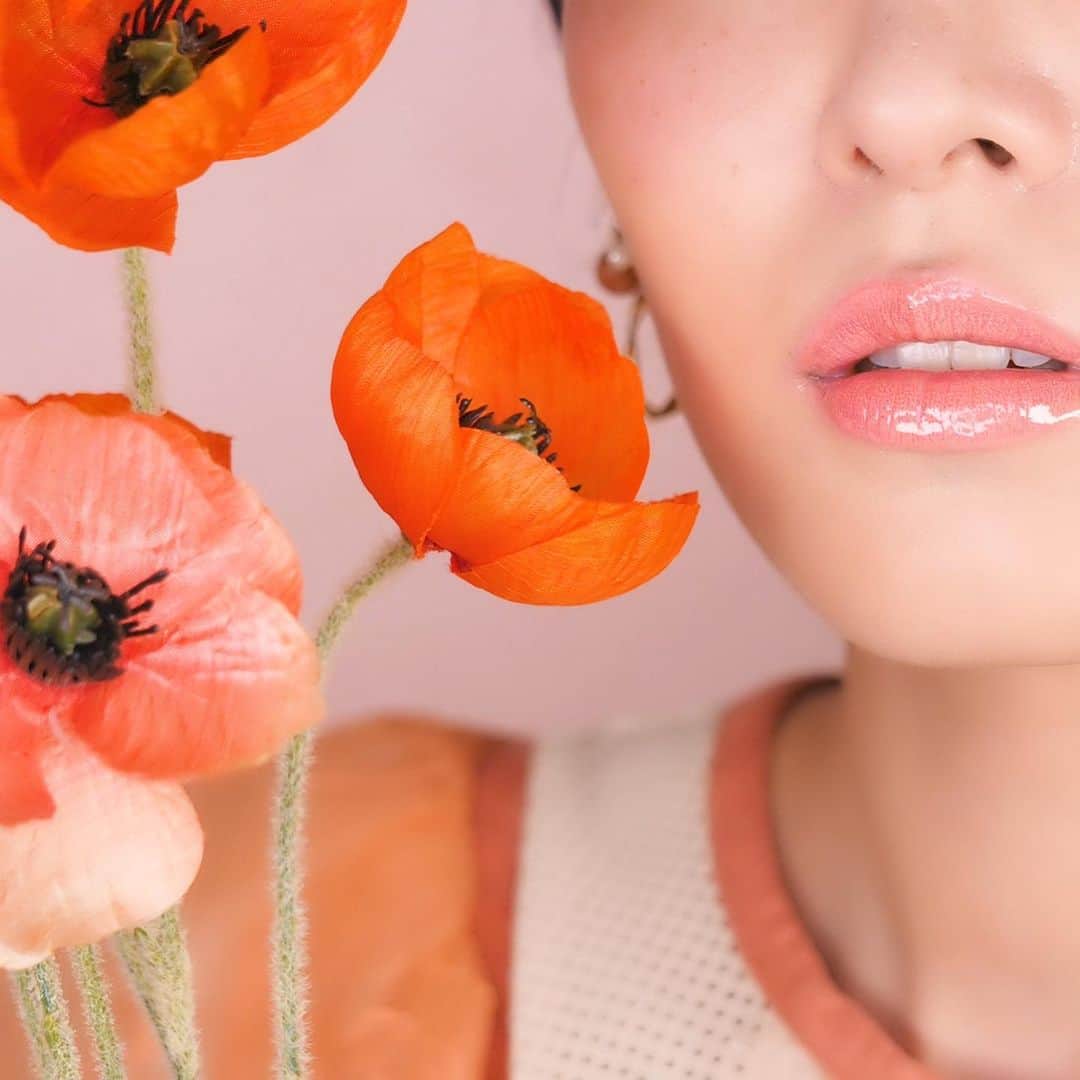 くまみきのインスタグラム：「ポピー💐﻿ ﻿ 花言葉は、「いたわり」「思いやり」「恋の予感」「陽気で優しい」。﻿ ﻿ つけるだけで、あなたがいるとその場が明るい雰囲気になるねと言われるようなハッピーカラーのリップに仕上げました🥰﻿ ﻿ 詳細はストーリーズの #HANAEMI をチェックしてね☺️﻿ ﻿ #リップ #グロス #ポピー #プロデュースコスメ」