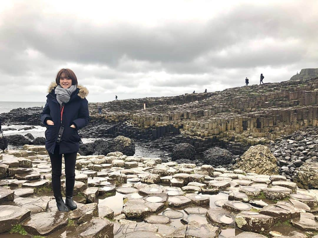 宮司愛海さんのインスタグラム写真 - (宮司愛海Instagram)「北アイルランド編🇬🇧 イニシュモア島へ行った翌日は、西部のゴールウェイから高速バスに乗って北アイルランドへ。 北アイルランドはアイルランドと同じ島にありながらイギリス領なんです。 国境はバスに乗ったまま通過するので、その存在をほぼ全く感じることなく、いつのまにか北アイルランドに入る、という不思議な感じでした😶 (アイルランドは「Coach」と呼ばれる高速バスが発達していて、島内の至るところに行くことができます。) . 中心街のベルファストは、街並みや人々もゴールウェイとはまた違う、都会な雰囲気。数百年という月日を経てきた古い建物で街が構成されているものの、どこか漂う洗練された空気はイギリスだからこそのものなんでしょうか？ブリティッシュっぽさを感じました🇬🇧 . 北アイルランドでは、ベルファストから1時間ほどの北部にある「ジャイアンツコーズウェイ」という世界遺産へ。昔、アイルランドに住んでいた巨人が、対岸のスコットランドにいる巨人に会いに行くため作ったという伝説もある世界遺産です。 ここにあるのは、自然が作り出した六角形の石柱群！ 火山から流れ出し固まった溶岩が長い月日をかけて侵食などを繰り返しこの形になったそうです。 綺麗な形の六角形の上に乗ってお願いごとをすると叶うとどこかで聞いたので探してお願いしてきましたよ🤭 ほかにも巨人のオルガンと呼ばれる石柱の集まりや、巨人のブーツなど、巨人の伝説にちなんで名付けられた遺産がたくさんありました。  あいにくの雨で寒さ増し増しでしたが...自然にできたとは思えない不思議な光景が強く心に残りました✌︎ . 北アイルランドはベルファストの方もゆっくり見たかったのですがあまり時間がなく...。 機会があればまたゆっくり行きたいなあ。 . #全体的に灰色 #ジャイアンツコーズウェイ」11月21日 22時28分 - manami_miyaji