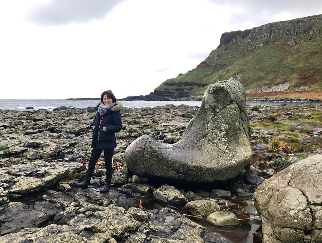 宮司愛海さんのインスタグラム写真 - (宮司愛海Instagram)「北アイルランド編🇬🇧 イニシュモア島へ行った翌日は、西部のゴールウェイから高速バスに乗って北アイルランドへ。 北アイルランドはアイルランドと同じ島にありながらイギリス領なんです。 国境はバスに乗ったまま通過するので、その存在をほぼ全く感じることなく、いつのまにか北アイルランドに入る、という不思議な感じでした😶 (アイルランドは「Coach」と呼ばれる高速バスが発達していて、島内の至るところに行くことができます。) . 中心街のベルファストは、街並みや人々もゴールウェイとはまた違う、都会な雰囲気。数百年という月日を経てきた古い建物で街が構成されているものの、どこか漂う洗練された空気はイギリスだからこそのものなんでしょうか？ブリティッシュっぽさを感じました🇬🇧 . 北アイルランドでは、ベルファストから1時間ほどの北部にある「ジャイアンツコーズウェイ」という世界遺産へ。昔、アイルランドに住んでいた巨人が、対岸のスコットランドにいる巨人に会いに行くため作ったという伝説もある世界遺産です。 ここにあるのは、自然が作り出した六角形の石柱群！ 火山から流れ出し固まった溶岩が長い月日をかけて侵食などを繰り返しこの形になったそうです。 綺麗な形の六角形の上に乗ってお願いごとをすると叶うとどこかで聞いたので探してお願いしてきましたよ🤭 ほかにも巨人のオルガンと呼ばれる石柱の集まりや、巨人のブーツなど、巨人の伝説にちなんで名付けられた遺産がたくさんありました。  あいにくの雨で寒さ増し増しでしたが...自然にできたとは思えない不思議な光景が強く心に残りました✌︎ . 北アイルランドはベルファストの方もゆっくり見たかったのですがあまり時間がなく...。 機会があればまたゆっくり行きたいなあ。 . #全体的に灰色 #ジャイアンツコーズウェイ」11月21日 22時28分 - manami_miyaji