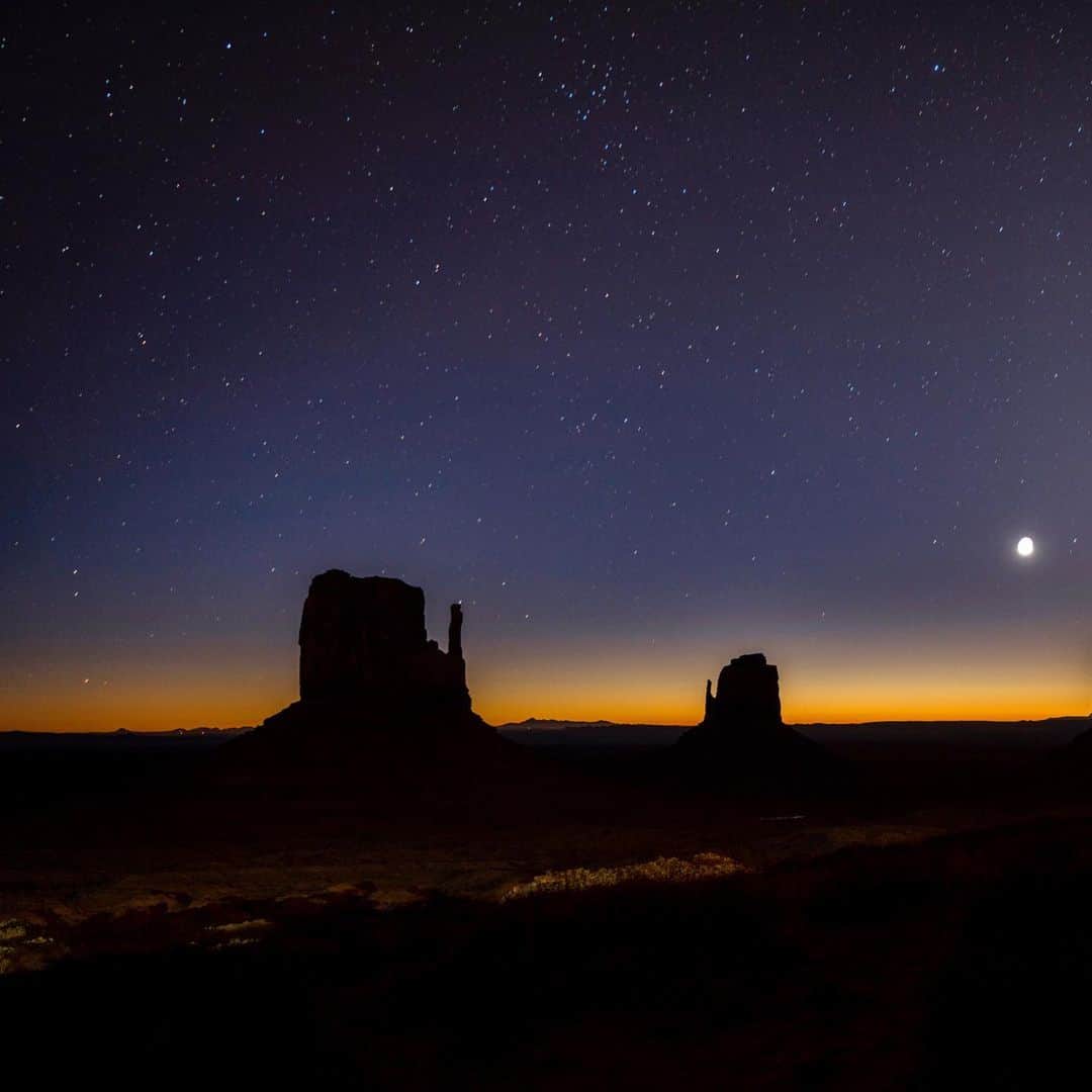 クリス・バーカードのインスタグラム：「The push and pull of twilight is one of the more fleeting moments during the day. A long exposure reveals stars but also the very early beginnings of sunrise on the horizon. This was shot at 5 AM and the naked eye could only see the faint silhouettes of the mittens & the moon. I love how photography reveals a world we can only attempt to see.」