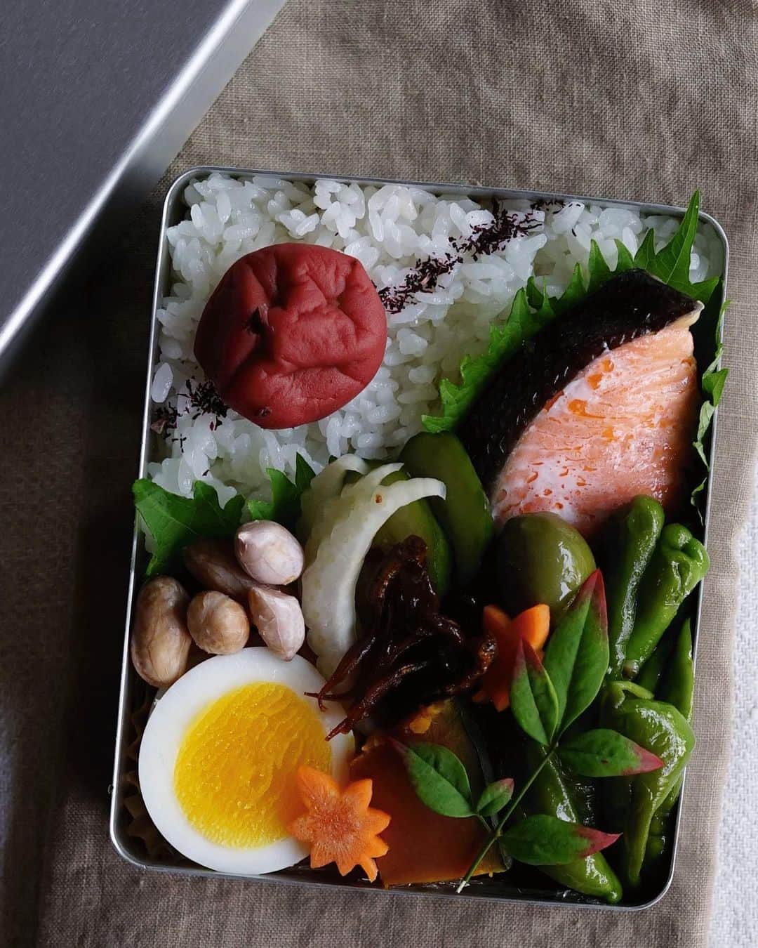 Ryoko Yunokiのインスタグラム：「+ + + Grilled salted salmon bento/焼き塩鮭弁当 . *rice and umeboshi *grilled salted salmon *sauteed bell pepper *nukazuke pickled celery and cucumber *boiled peanuts *dashi-simmered acorn squash *soy-glazed fish *hard-boiled egg . ＊ご飯と梅干し ＊焼き塩鮭 ＊万願寺唐辛子のソテー ＊セロリと胡瓜の糠漬け ＊茹でピーナッツ ＊南瓜の出汁煮 ＊玉筋魚の佃煮 ＊ゆで卵 + + + #bento #お弁当 #丸の内弁当 #f52grams #アルミ弁当箱」