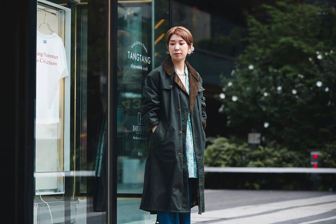 のインスタグラム：「Barbour People アーカイブを復刻したワックスドコットン製のトレンチコート。 ゆったりとしたシルエットや、襟元の太畝コーデュロイ、裏地に配されたバブアーオリジナルのタータンチェック柄など、アイコニックなディテールはそのままに、着丈のバランスを調整した、ロング丈でインパクトのある、クラシカルな趣の一枚です。  #barbour #バブアー #barbourpeople #UK」