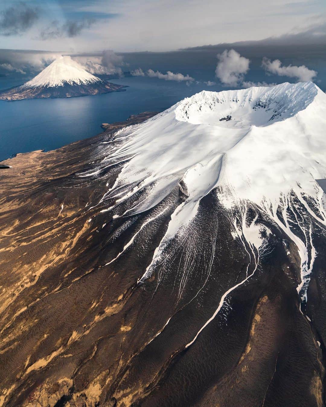 クリス・バーカードのインスタグラム：「I’ve been home for just over a day after spending the last 2 weeks in one of my favorite places. Alaska’s remote Aleutian chain. It also happens to be one of the more remote and challenging places to access. We decided to gamble this time and go late in the season. Most days hovered below freezing with winds gusting up to 50+ knots regularly. I felt prepared for the conditions mentally & physically but it still wrecked my body and my equipment massively. We walked away from the trip with an overwhelming near 30,000 images.  I’ve found the hardest part of being in this place is leaving... and I don’t mean because it’s so beautiful but because the weather get so bad that being stuck there for 2+ weeks with limited food is a common problem. This place is notorious for grounded flights. Half our crew had to wait out the bad weather for 4 extra days and is just finally departing tonight.  @_ryanhill_ @benweiland @parkercoffin @natezoller @harrisonsan @mikey_rangel @roark @sonyalpha @blackdiamond @gomacro」