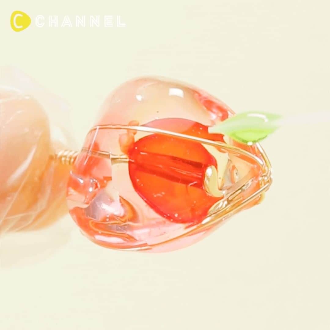 C CHANNEL-Art&Studyのインスタグラム：「💟The Inside is a ♡ DIY Resin Heart Pendant🧡 💟中が透けて見える♡ほおずきペンダント🧡 . 🎨Follow me👉 @cchannel_artandstudy 🎵 💡Check👉 @cchannel_girls 🎶 📲C CHANNELのアプリもよろしくお願いします💕 . [Things to prepare] ・ Heart-shaped silicon mold ・ T pin ・ Bead red ・ LED & UV craft resin solution ・ UV light (9w) ・gloves ・wire ・ Nippers ・ Gemstone red, yellow, green ・ Leaf parts ・ Round pincers ・ Flat pincers ・necklace chain . [Steps] 1. Pour the resin into the mold and harden it together with the T pin through the beads. 2. Pour the resin again and pile on and harden. 3. Remove from the mold and wrap the wire using pincers. Cut excess length with nippers. 4. Coat the colored resin in the order of red, orange and green. 5. Round the tip of the T pin and close it through the leaf parts and necklace chain. . * When handling the resin, cover your hands with poly gloves, etc., so that the resin does not touch the skin. * Use of gloves and ventilation of the room are recommended during work. . . かわいいほおずきをレジンで表現しました♡ . 【用意するもの】 ・ハート型のシリコンモールド ・Tピン ・ビーズ 赤 ・LED＆UVクラフトレジン液 ・UVライト (9w) ・手袋 ・ワイヤー ・ニッパー ・宝石の雫 赤、黄、緑 ・リーフパーツ ・丸ヤットコ ・平ヤットコ ・ネックレスチェーン . 【作り方】 1. 型にレジンを流しビーズを通したTピンと一緒に固める。 2. もう一度レジンを流し1. を重ねて固める。 3. 型から取り外し、ヤットコを使いワイヤーを巻き付ける。余分な長さはニッパーで切る。 4. 着色したレジンを赤、オレンジ、緑の順番でグラデーションになる様にコーティングする。 5. Tピンの先を丸め、リーフパーツとネックレスチェーンを通して閉じ完成。 . ※レジンを扱う際は、ポリ手袋などで手を覆い、皮膚にレジンがつかないようにご注意ください。 ※作業中は手袋の使用、部屋の換気をおすすめします。 ※レジンは高温となりますので取り扱いには十分に注意してください。 . . #japaneseculture#autumnmood#resinart#resincraft##handmadeaccessory#handmadeaccessories#resinaccessory#accessoryaddict#resinartists#kawaiiresin#easycrafts#beads#handmadejewelry#beadedjewellery#Pendant#handmadependant#resinnecklace#resinpendant#resincrafting#accessoryaddict#instacraft#craftvideo#craftsofinstagram#fall#autumn#pendant#red#hozuki#cchanDIY」