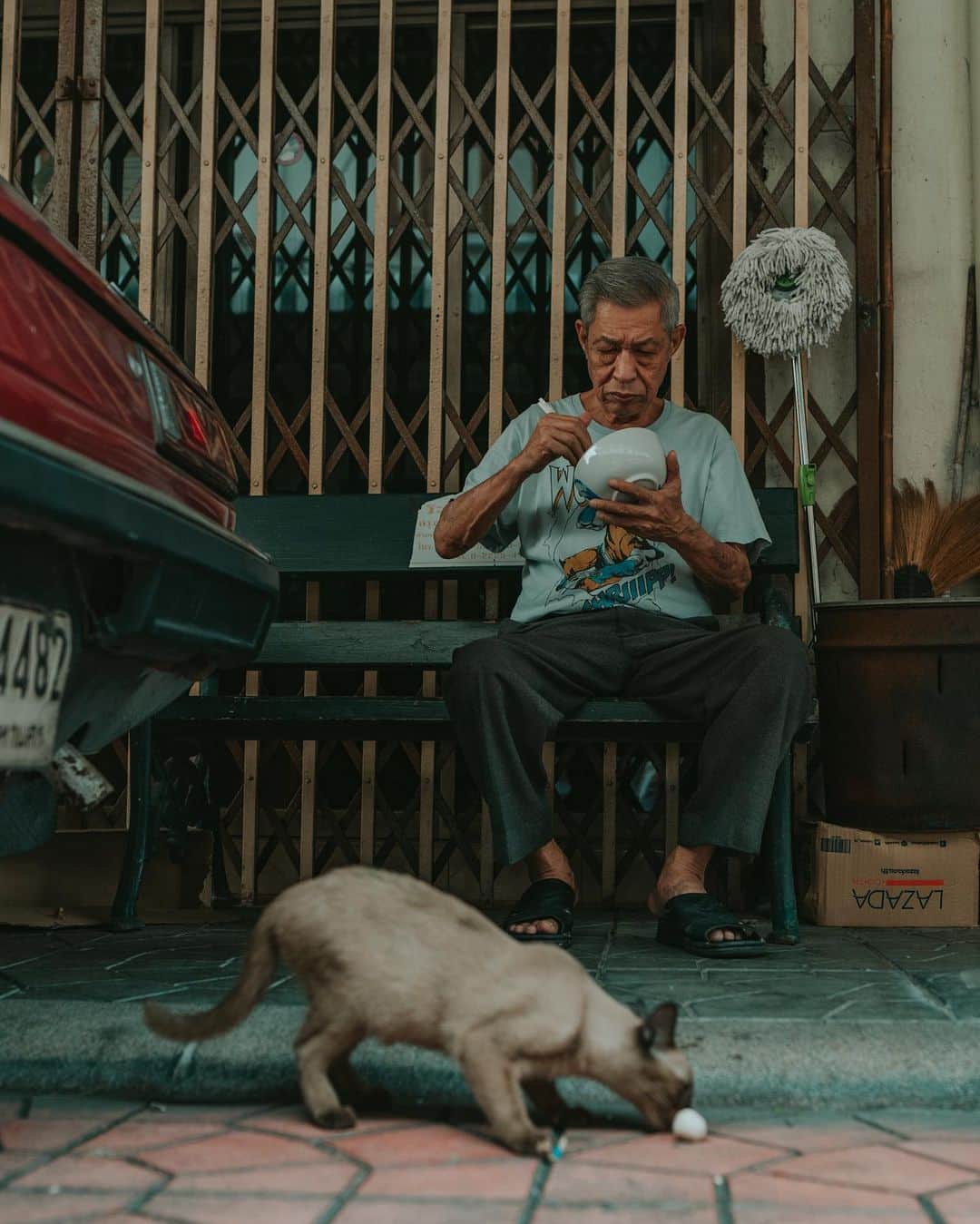 Putri Anindyaのインスタグラム：「Siamese // these are photos about my happiness to find siamese cat in Siam that leads me to this wonderful old man. if you guys watch my stories for sure you know my siamese cat, Olin, that look like this cat! ⁣ It was in the little alley, near of The Deck, a rooftop bar where you can see wat arun in sunset. Suddenly, there was a cat walked out from under the car towards the old man.⁣ ⁣ When I walked passed this scene, I asked @capra311 ‘s opinion, “should I go back and take photo of the cat and him?” Before he answered, my feet automatically took me to the old man and the cat and I have my mouth opened, “excuse me, May I take photo of this cat?” He smiled and call the cat out because the cat was quite afraid with stranger. Then he threw his meatball to the cat so I can take picture of olin’s brother!⁣ ⁣ Another thing, about street photo, I have some questions regarding do I ask permission to the people when I shoot? My answer is most of the times I don’t. ⁣ ⁣ About street photos, I love to take the image as natural as possible. But half of the time I also ask permission after I took candid shots of them. So when they say no, i already have the portrait but when they say yes, it’s a bonus :)⁣ ⁣ You probably think i’m being rude and so on but it’s the beauty of street photos. To capture the moment that can’t be repeated. To capture the strangers that catches your eyes. The everyday scene in your own perspective. ⁣ ⁣ ⁣ You can ask more question in the comments I will be happy to answer :)」