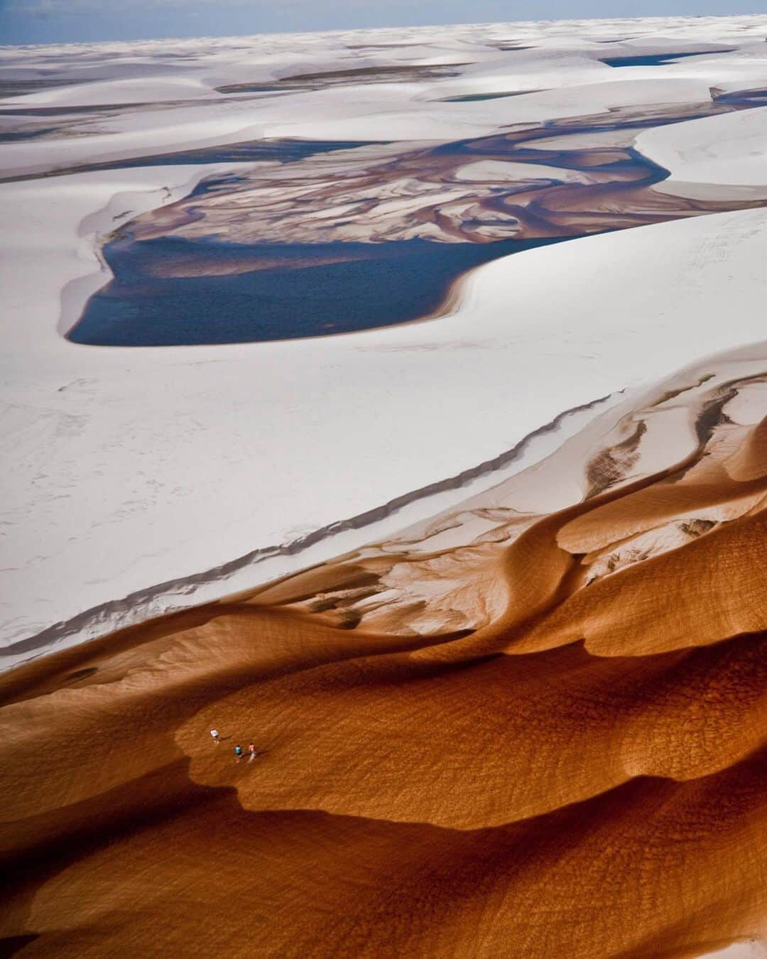 National Geographic Travelさんのインスタグラム写真 - (National Geographic TravelInstagram)「Photo by George Steinmetz @geosteinmetz | My ground crew wades through a tannin-stained river in Lençois Maranhenses National Park, Brazil. During the rainy season the hollows between the mobile dunes become lakes of freshwater, and the sands are cut by rivers flowing from the jungle to the sea. To explore more of our Earth from above, follow @geosteinmetz.」11月27日 2時25分 - natgeotravel