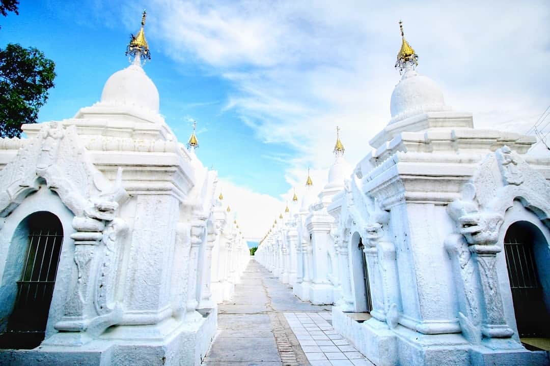 旅行比較サイト・トラベルコ 理想の旅を、いちばん安く。のインスタグラム：「#ミャンマー取材記🇲🇲 #マンダレー 編  今回の取材では、ミャンマー第ニの都市 #マンダレー にも行ってきました。ここは19世紀にミャンマー最後の王朝として栄えた古都であり、旧王宮や歴史ある僧院が点在します。中でも目を惹くのが #クドードォパゴダ ！　真っ白な小仏塔（その数なんと729基！）がズラズラズラ～っと境内を埋め尽くすさまは圧巻。それぞれの小仏塔の中には経典を掘った大理石が1枚ずつ納められているそうです😮  そしてマンダレーといえば外せないのが #マンダレーヒル 。標高236m、丘全体が寺院となったマンダレー最大の聖地は夕日スポットとしても有名ですが、この日は天候が良くなかったため街並みの眺望を楽しみました。  スタッフ一行はさらに足を延ばして郊外の #アマラプラ も訪問。こちらもかつてミャンマーの首都が置かれていた歴史ある街で、現在は絹や綿の織物産業が盛んだそう。工房兼ショップで機織りの様子を見学させてもらいましたが、現地の方々が鮮やかな手つきで仕上げる織物はどれも色彩豊かで本当に素敵でした！ * *﻿ *﻿ ★12/1（日）まで！★「トラベルコ2020オリジナルカレンダー」プレゼントキャンペーン実施中！詳細は @travelko_chan のプロフィールリンクからご覧ください。 *﻿ *﻿ *﻿ #ミャンマー #myanmar #mandalay #kuthodawpagoda #mandalayhill #amarapura #ミャンマー旅行 #観光ビザ免除継続 #海外旅行 #travel #trip #sightseeing #フォトジェニック #旅行好きな人と繋がりたい #女子旅 #カメラ女子 #カメラ男子 #一人旅 #instatravel #travelgram #instagood #travelko #トラベルコ #トラベルコちゃん #トラベルコカレンダー2020 @yokosomyanmar」