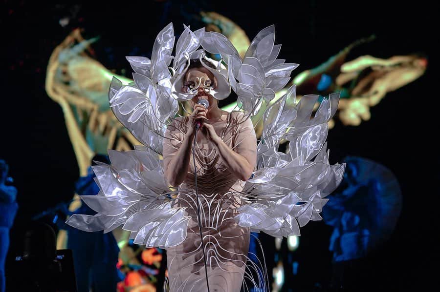 Iris Van Herpeさんのインスタグラム写真 - (Iris Van HerpeInstagram)「Breathtaking @bjork is now stunning Europe with her new multi sensorial 'Cornucopia’ tour, so proud to be part of these revolutionary shows.  The 'Sphaera’ dress is created from transparent organza leaves that are framed in a hybrid material of laser-cut white cotton and mylar, which then are layered sculpturally into a fine frame of water-jet cut stainless steel lines. The leaves are then hand-bent into shape around the body, and can be continuously re-shaped to change silhouette. A fine network of stamen expose outward, finished with handmade feathers of shuiro red and white. The 'Sphaera' dress was inspired by the concept of a living orchid avatar that is layered like an aura around Björk, magnifying her movements.  Mask by @james.t.merry  Photo by @santiagraphy  #irisvanherpen #bjork #sphaera #cornucopia」11月29日 22時19分 - irisvanherpen