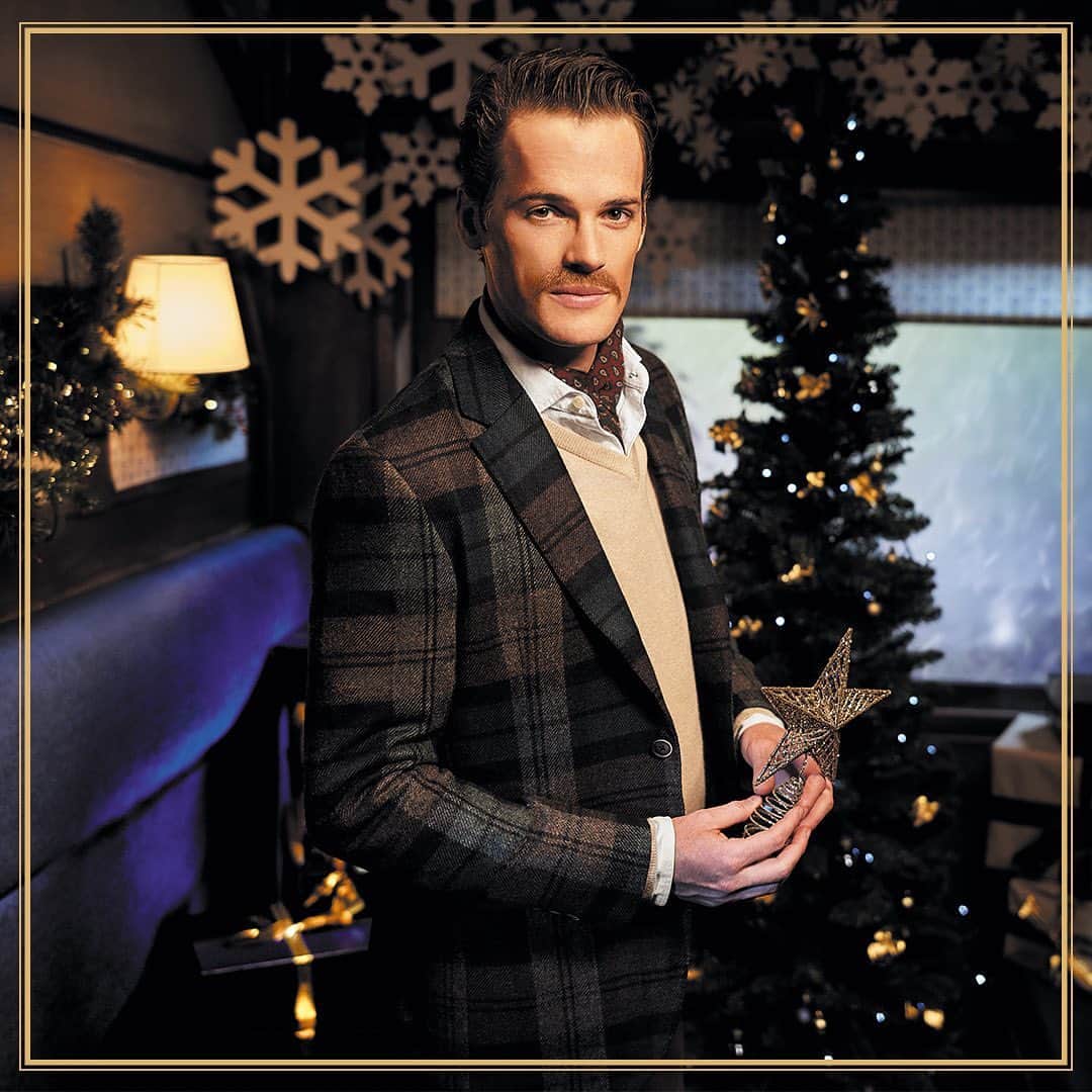 ハケットのインスタグラム：「The Christmas Tree dresser's flamboyance is reflected across his wardrobe as well as his tree, pairing a bold checked blazer with a beige V-neck jumper and open Oxford shirt. He finishes the look off with a printed neck scarf and has purposely replicated the check from his suit onto this years' baubles. #Hackett #TwelveGentlemenOfChristmas #HackettChristmasExpress」