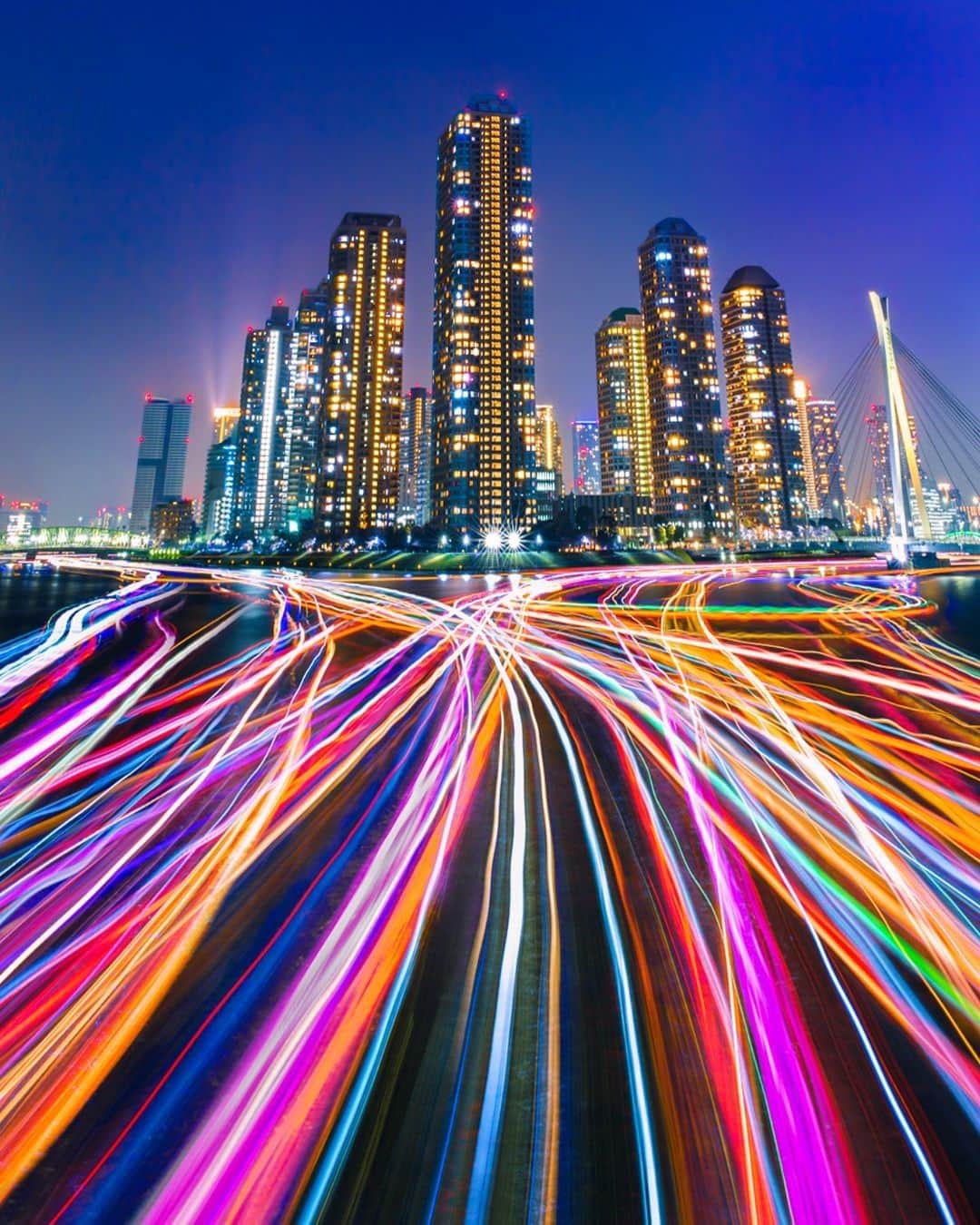 Lonely Planetのインスタグラム：「'Eitai Bridge is a great place in #Tokyo to meet other photographers, all trying to capture the party boat lights floating along the Sumida River in front of the Tsukuda skyscrapers. This photo was created over 2 hours by taking 30 long exposures of around 90 seconds each as the boats passed by. Then stacking them all on top of each other to create a neon wonderland!' – @wheresshelly -- That's a wrap for this weekend's takeover! Tap our link in bio for more info on visiting #Japan during blossom season.」