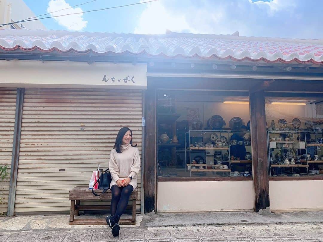 長嶺菜菜子のインスタグラム：「. Good morning🌞﻿ ﻿ ﻿ 壺屋やちむん通り﻿ でひと休憩😚✨﻿ ﻿ ﻿ やちむん＝焼き物﻿ 沖縄の方言﻿ ﻿ ﻿ 焼き物通りのここは﻿ すごく雰囲気が良くて﻿ 時間がゆっくり流れてる👣﻿ ﻿ ﻿ 猫ちゃん🐈もいて﻿ ブーゲンビリアやハイビスカスも咲いていて🌺﻿ 南国の雰囲気に﻿ 沖縄の昔ながらの家もあったりして﻿ ﻿ ﻿ ゆっくり散歩するにはちょうどいい観光地🙌﻿ 表通りだけじゃなくて裏通りもふらっと入ってみると面白い景色が観れるかも😚﻿ ﻿ ﻿ ﻿ ★------------------------------------------------☆ ﻿ #沖縄人 #沖縄出身 #うちなんちゅ﻿ #八重歯 #でこっぱち﻿ #やちむん #やちむん通り﻿ #沖縄観光 #沖縄観光オススメ #那覇市壺屋 #那覇市観光﻿ #焼き物﻿ #恋するやちむん﻿ #つぼや工藝店﻿ #散歩﻿ #那覇散歩﻿」
