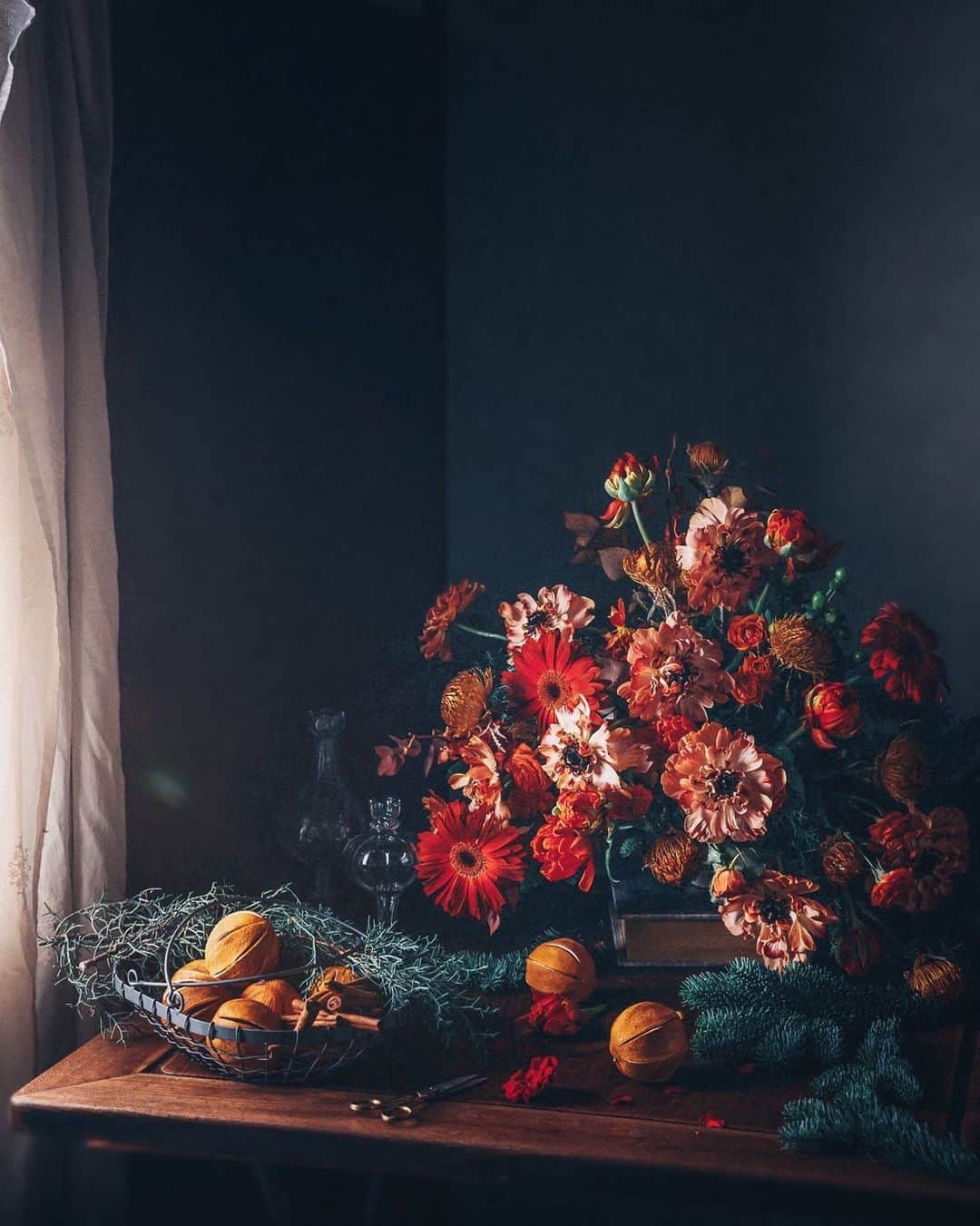 柳澤麻衣のインスタグラム：「I start preparing for Christmas. Have a lovely weekend to all🎄 . 赤い花とエバーグリーンのアレンジメント。クラシックなクリスマスの雰囲気にアレンジしました。 甘い香りのオレンジホールはリース用です🍊🍊🍊」
