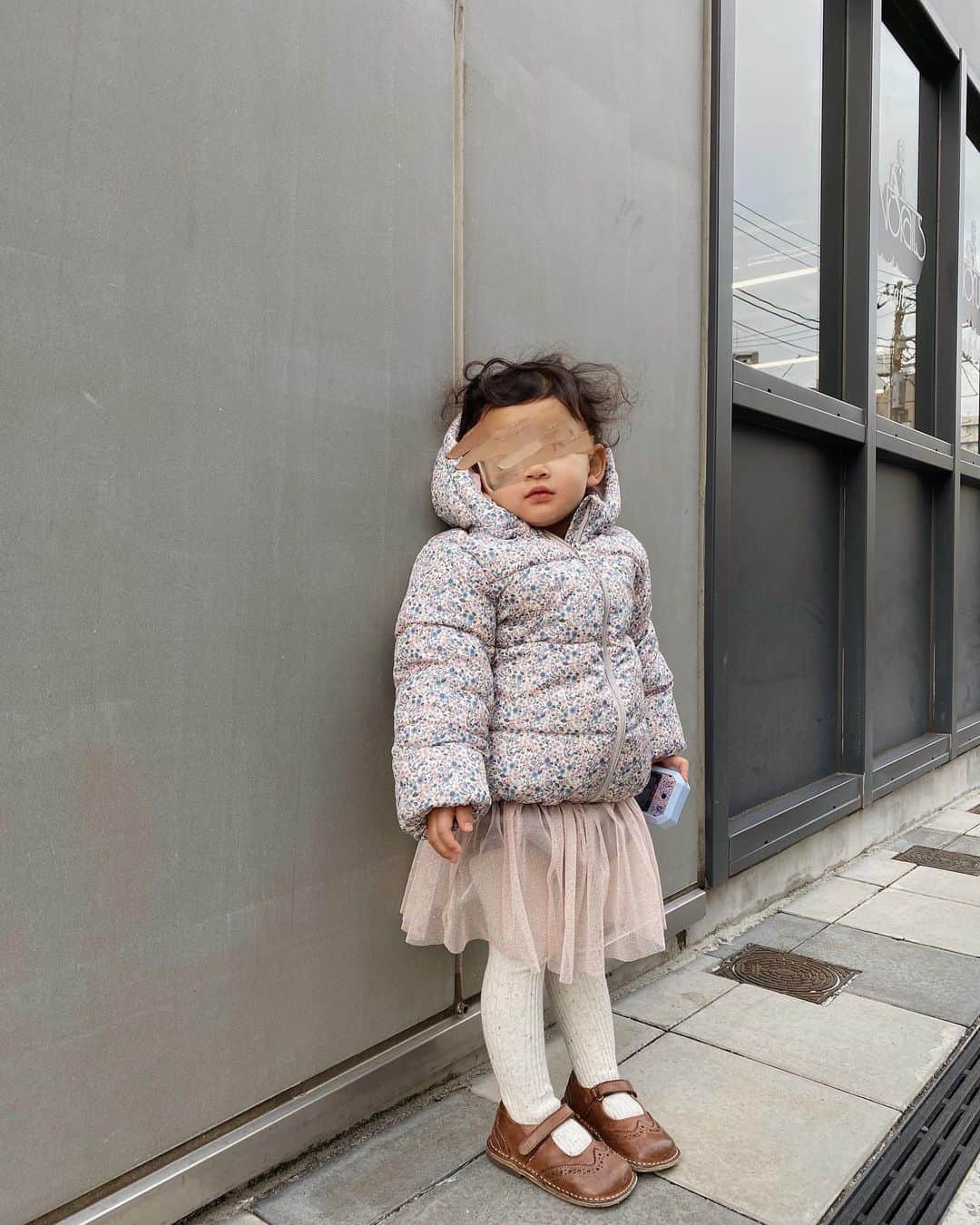 目見田早弥子のインスタグラム：「|꙳ 気付けば今日は１歳最後の日。 短い髪の毛も短いなりに伸びてきて爆発あたま.. 本格的に寒くなってきたし 娘も自分の足で歩くことが増えたので 今年からダウンデビューしてみました。 @hm_kids の女の子らしい小花柄ダウン❁ 大きめ狙って90にしました！来年も余裕かな。 フードも取り外せるしプチプラなので 公園行く時とかもガシガシ遊べて良し◯ ちなみに今日は娘がこのスカートを絶対に履くというので えーと思ったけど(私が買ったのに🤣) ダウンとスカートがマッチしてて結構可愛い👏🏻😂❣️ お出かけの時は誕生日プレゼントのアナ雪スマホ持って 写真パシャパシャしてます❄️ #HMKids#HMxME#HMジャケット#HM」