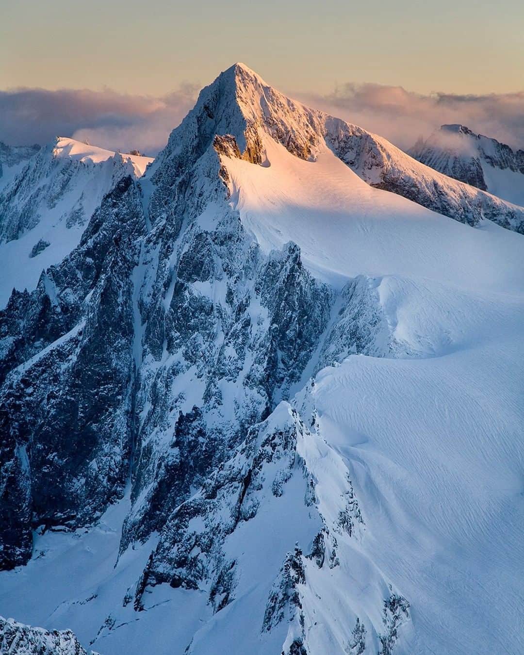 National Geographic Travelさんのインスタグラム写真 - (National Geographic TravelInstagram)「Photo by @stephen_matera | The sun rises over Eldorado Peak in North Cascades National Park, Washington. The North Cascades are a rugged wilderness of old-growth forests, rock, and ice with over 300 active glaciers. One of the few roads that passes through this area is the North Cascades Highway, which is closed in winter because of deep snowfall and avalanche hazards. Most of the hiking and climbing in this beautiful wilderness requires long approaches with thousands of feet of elevation gain. Follow me @stephen_matera for more images like this from Washington and around the world. #northcascades #wilderness #aerialphotography」12月16日 18時09分 - natgeotravel