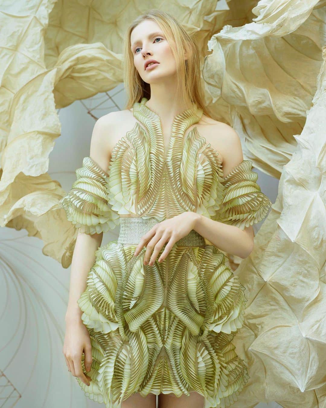 Iris Van Herpeさんのインスタグラム写真 - (Iris Van HerpeInstagram)「Organic memory ~ the ‘Foliage’ dress is on view as part of the Boundless Encounters exhibition along with 5 other Iris van Herpen Couture dresses. The Foliage dress is 3D printed through PolyJet tech which took 260 hours of printing. The resin cured when exposed to ultraviolet light, obtaining the final shape after post-processing when stresses within the material deform. Three variations of this material were altered on droplet level, achieving the color and transparency. This dress fuses precisely controlled digital 3D modeling and the less predictable analog nature of deformation. In collaboration with TU Delft. The exhibition is on display at the Zhejiang Art Museum until February 10th, 2020.  Image: @leah_rodl shot by Jean-Baptiste Mondino  Dress: made in collaboration with @tudelft  Styling: @jerry_stafford  Casting: Maida Boina & @maximevalentini  Hair & Makeup: @lydialeloux  #irisvanherpen #zhejiangartmuseum #boundlessencounters」12月16日 23時45分 - irisvanherpen