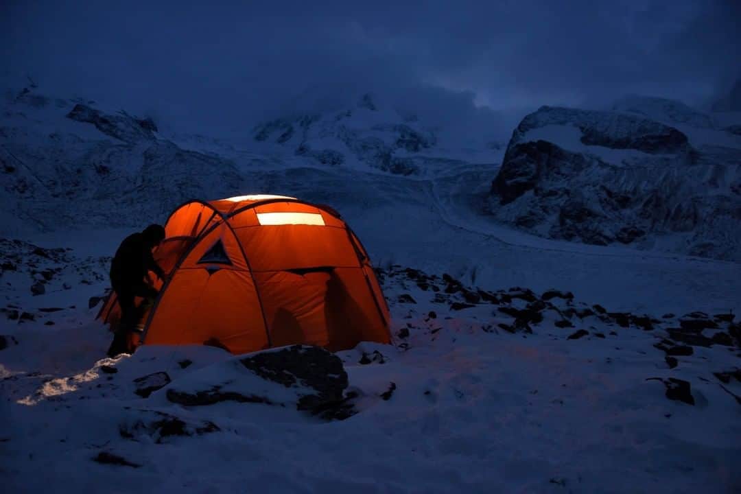 National Geographic Travelさんのインスタグラム写真 - (National Geographic TravelInstagram)「Photo by Robbie Shone @shonephoto | A cold night ahead! Isolated on the Gorner Glacier in Switzerland during an expedition to explore moulins and glacier caves, a team member climbs back inside a tent, where it is much warmer. The early evening light illuminates the distant mountains.」12月18日 6時05分 - natgeotravel