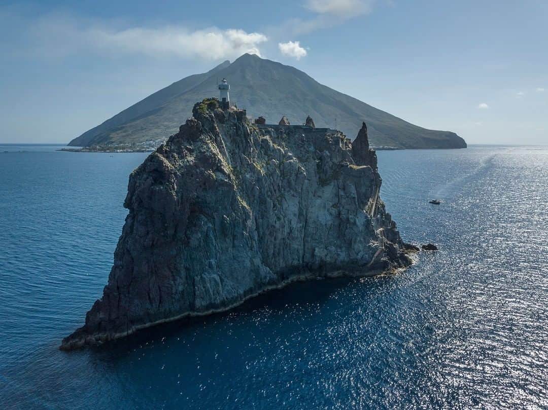 National Geographic Travelさんのインスタグラム写真 - (National Geographic TravelInstagram)「Photo by @andrea_frazzetta | Stromboli Island looms behind Strombolicchio, its sister island, off the coast of Italy in the Tyrrhenian Sea. I recently photographed these islands for “What it’s like to live in the shadow of an active volcano,” now on the National Geographic website. As the writer Giannella Garrett explains: “I’m energized by the experience of hiking this volcano again. But I realize I don’t need to ascend Stromboli’s summit to find satisfaction. Sometimes a volcano is best viewed from below, with one’s eyes to the skies in gratitude.” To see more photos from my travels, follow me @andrea_frazzetta. #stromboli #volcano #italy #natgeotravel」12月22日 2時06分 - natgeotravel