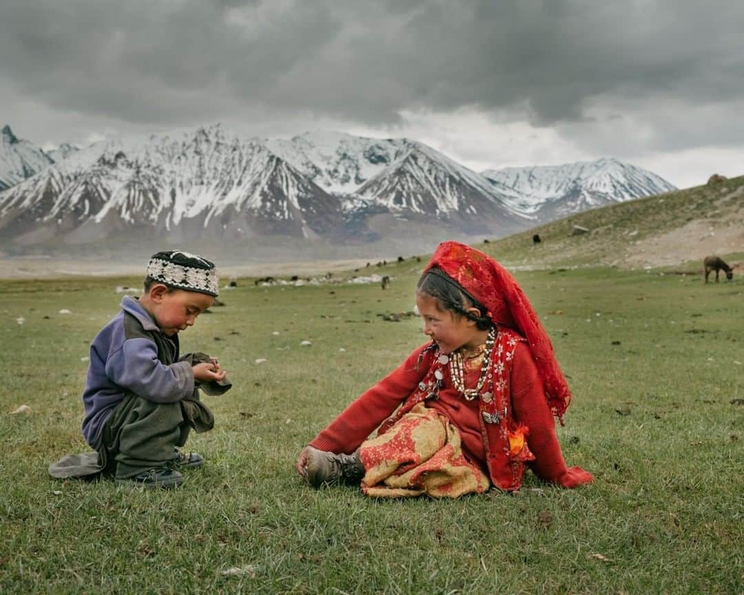 ナショナルジオグラフィックさんのインスタグラム写真 - (ナショナルジオグラフィックInstagram)「Photo by Matthieu Paley @paleyphoto I Two young Kyrgyz play in the grass at the edge of their nomadic camps. Their parents are out herding yaks below Afghanistan’s mighty Pamir Mountains, seen in the distance. Head over to @paleyphoto for more cultural encounters and to go behind the scenes.」12月22日 0時37分 - natgeo