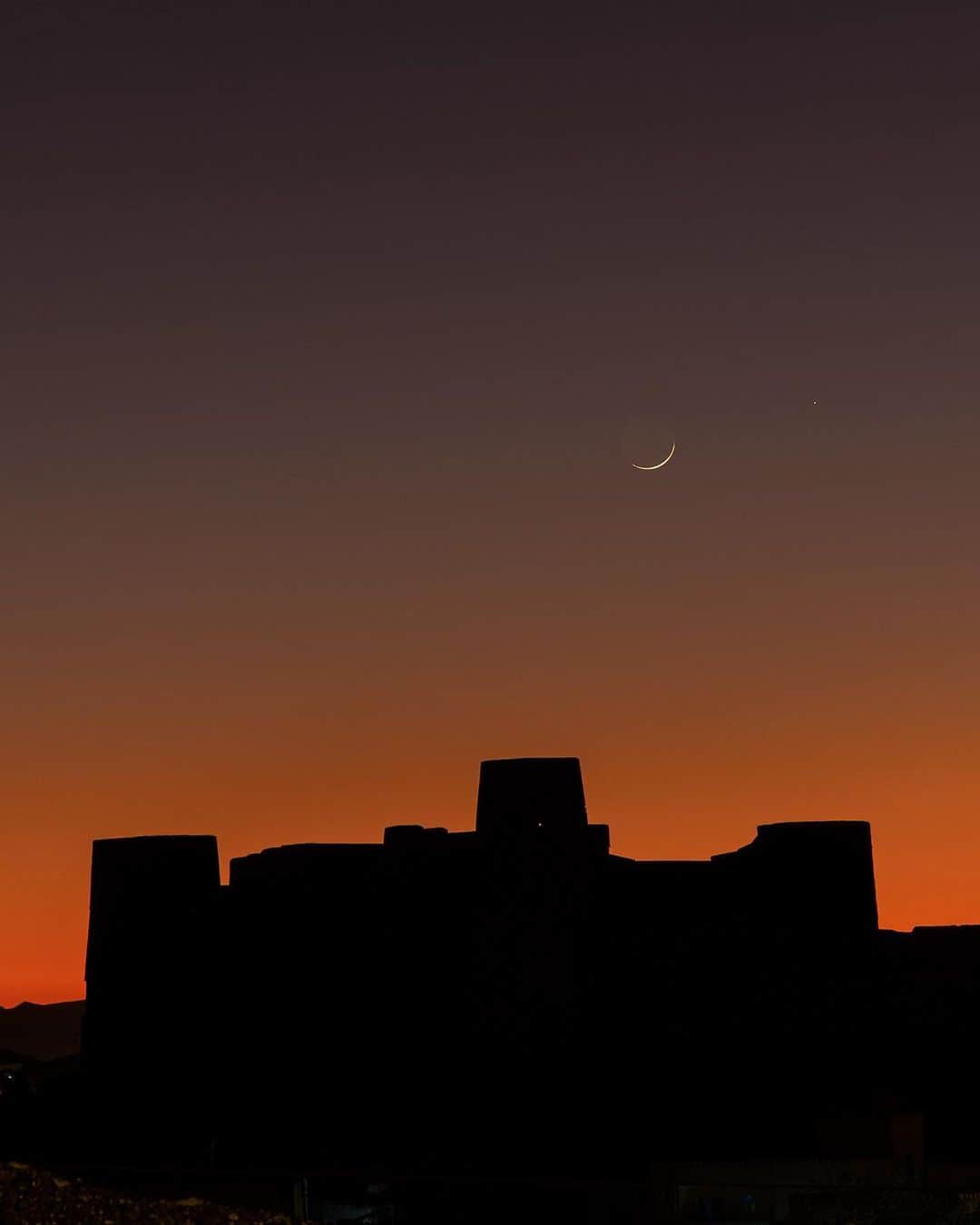 National Geographic Travelさんのインスタグラム写真 - (National Geographic TravelInstagram)「Photos by @BabakTafreshi | The new moon appears in a colorful dusk over Bahla Fort, a World Heritage site at the foot of the Jebel Akhdar highlands in Oman. Swipe for a closer view of the crescent moon and Saturn in a celestial conjunction, taken on December 27. Built in the Middle Ages, the fortress is one of four located around the town of Bahla.  Explore more World Heritage sites at night @babaktafreshi. #newmoon #middleeast #oman #bahlafort #worldheritage」1月7日 2時07分 - natgeotravel
