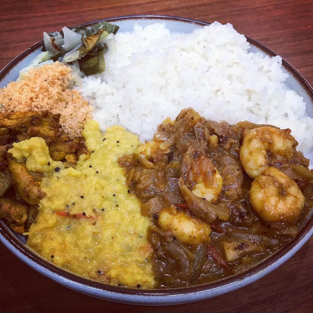 桜井誠のインスタグラム：「久々にカレー作り スリランカプレート 寒すぎたので買い物に行かずに家にあるもので。 ⭐︎冷凍のエビでシュリンプカレー ⭐︎パリップ ⭐︎クリスマスチキンの残りツナパハ炒め ⭐︎ポルサンボル ⭐︎下仁田ねぎのモージュ？ いろいろ混ぜてもぐもぐ。 今回は下仁田ねぎのモージュが1番のヒット。素揚げしてないからモージュじゃないのかな？笑 ホイルに包んで焼いた下仁田ねぎを、塩とココナッツビネガーで和えたもの。ねぎの甘みとビネガーの酸味が最高のハーモニー スリランカ料理は、家庭的で美味しい。体にスッと入っていく感覚。  #curry #スリランカ #SriLanka #カレー #スパイストラベラー」