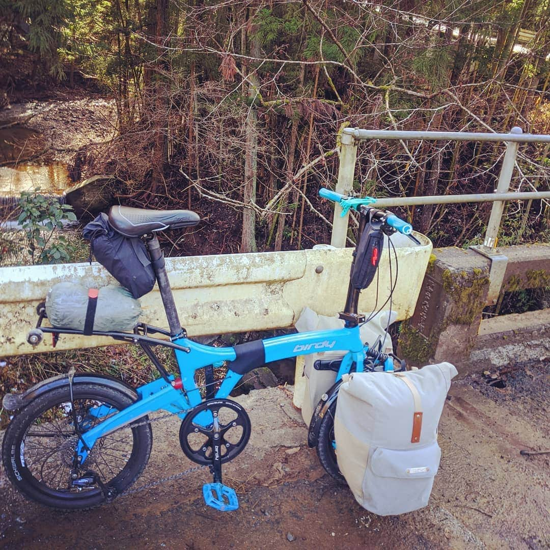 山下晃和さんのインスタグラム写真 - (山下晃和Instagram)「【BIKE&TRIP】小径の折り畳み自転車は食わず嫌いしていた  しかしながら、実際に旅してみたら、旅のカタチが変わった  ひたすら走りたいロードバイク、 林道を見つけたくなるグラベルロード、 シングルトレイルを繋ぎたくなるMTB  公共交通機関を使いたくなるのがBirdyの良さなのだと  電車はもちろん、飛行機、バス、タクシー全て輪行可能  島根のタクシー運転手は、「車椅子に比べれば軽いねえ」と持ってくれた。そうか、タクシーには車椅子が積めるんだ  孤独を好んで、砂漠、草原、山道、荒野とさんざん海外を走ったくせに  輪っかが小さいだけで 大自然の中を走りたいというよりは、人がいるところを走りたくなった  田舎に突然現れるオシャレなカフェ、おばあちゃんが独りで営んでいる小さな商店、未だに木造の駅舎、牧場に併設されているお土産屋さん  そこには人々の暮らしがあり、独特な空気があり、旅でしか出会わないであろう人がいた、全てがやさしかった  そして、重たいパニアを漕ぎ上げ、皆が待っているキャンプ場へと辿り着いた  小径折り畳み自転車の目的地は「人」だったんだ  そう思ったら、もっと漕ぎたくなった  #birdy #foldingadventure #foldingbike #chaoras #camp #camptouring #hotspring #Japan #touring #rinkou #輪行 #フォールディングアドベンチャー #スポーツ手ぬぐい #チャオラス」12月26日 15時16分 - travel_akikazoo