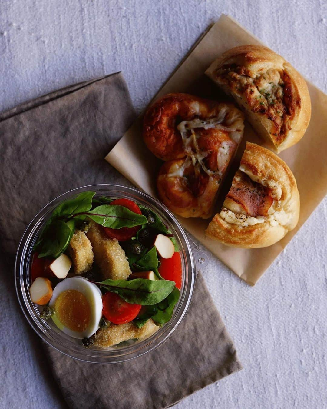 Ryoko Yunokiのインスタグラム：「Bread and salad bento/パンとサラダのお弁当 . *some bread *Green salad, topped with chicken nuggets, smoked cheese, hard-boiled egg, baby tomatoes and pickled capers, seasoned with salt/pepper and drizzled olive oil. . *パン *グリーンサラダ。チキンナゲット、スモークチーズ、ゆで卵、プチトマト、ケイパー。味付けは塩胡椒とオリーブオイル。 + + + #bento #お弁当 #丸の内弁当 #f52grams」