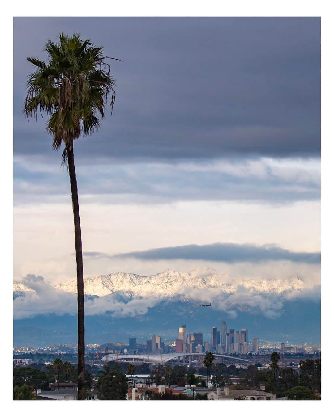 Pete Halvorsenのインスタグラム：「City of (snow) Angels. . Little dusting in the hills above DTLA last night as seen from Manhattan Beach. Swipe right for a different lens and closer look. In the foreground is @sofistadium the future home of the @rams / @chargers in Inglewood. . Leica SL/CL」