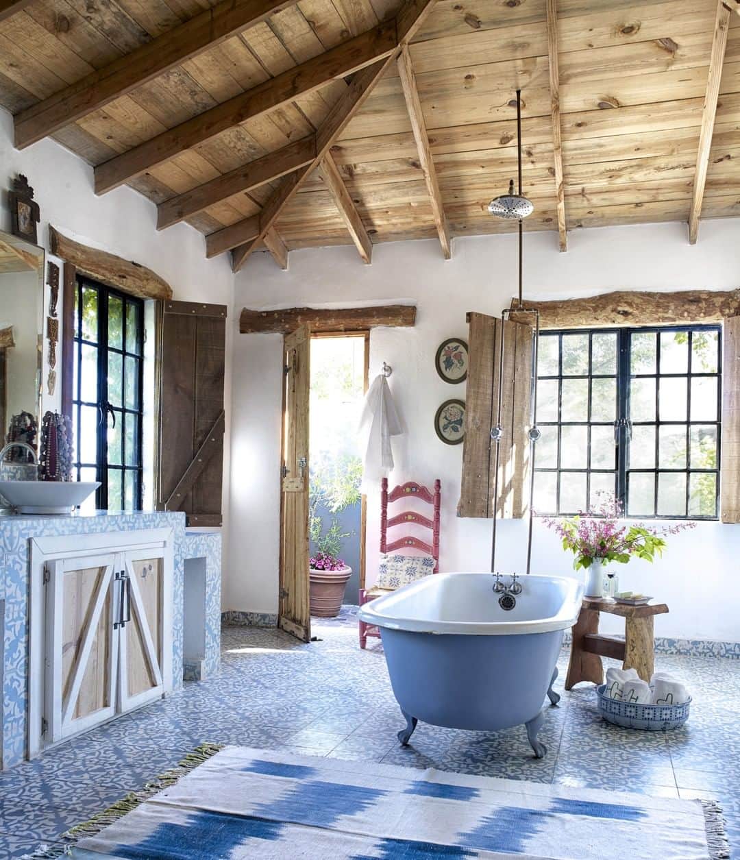 ELLE DECORさんのインスタグラム写真 - (ELLE DECORInstagram)「Tiles from Mooma Mosaicos, a Guadalajara company, cover the floors of this cool blue master bathroom in a ranch house designed by @alejandraredodesign. Redo, who built the home on a northern Mexico property that her grandfather won in a high-stakes game of poker, filled with space with pieces she collected over time, blending old and new with a fun sensibility that builds upon a charro theme. Other highlights of the master bath include an antique tub and a handmade Mexican chair and mesquite bench. The custom vanity has a Mirsa sink.  Click the link in bio for the full tour, as seen in the January/February 2020 issue. Photography by @williamwaldronphoto; Produced by Anita Sarsidi.」12月29日 7時00分 - elledecor