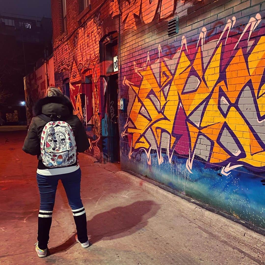 サイモンとマルティナのインスタグラム：「Stumbled across Graffiti Alley while home for the holidays in #Toronto (swipe for all the photos~) Didn’t even know this area existed 🎨 Everything is drenched in bright colours, intersecting lines with sharp and soft edges. This alley is just the right amount of unpolished scruffy but also...somehow clean? 🇨🇦😂 Normally, mismatched streetlights shining irregular blue and warm tones would irk me, but in Toronto it casts an extra magical look to the already glowing city sky. And what a view of the largest Christmas glow stick—the CN Tower! I love this colour changing chameleon of a landmark. It’s a crucial part of what makes the Toronto skyline unique. It’s neat to re-discover the city you grew up in ❤️ Ps-> 5th picture: is that a quote from Mr.Darcy (Pride & Prejudice) mixed with a heartbreaking quote from Severus Snape (Harry Potter)?」
